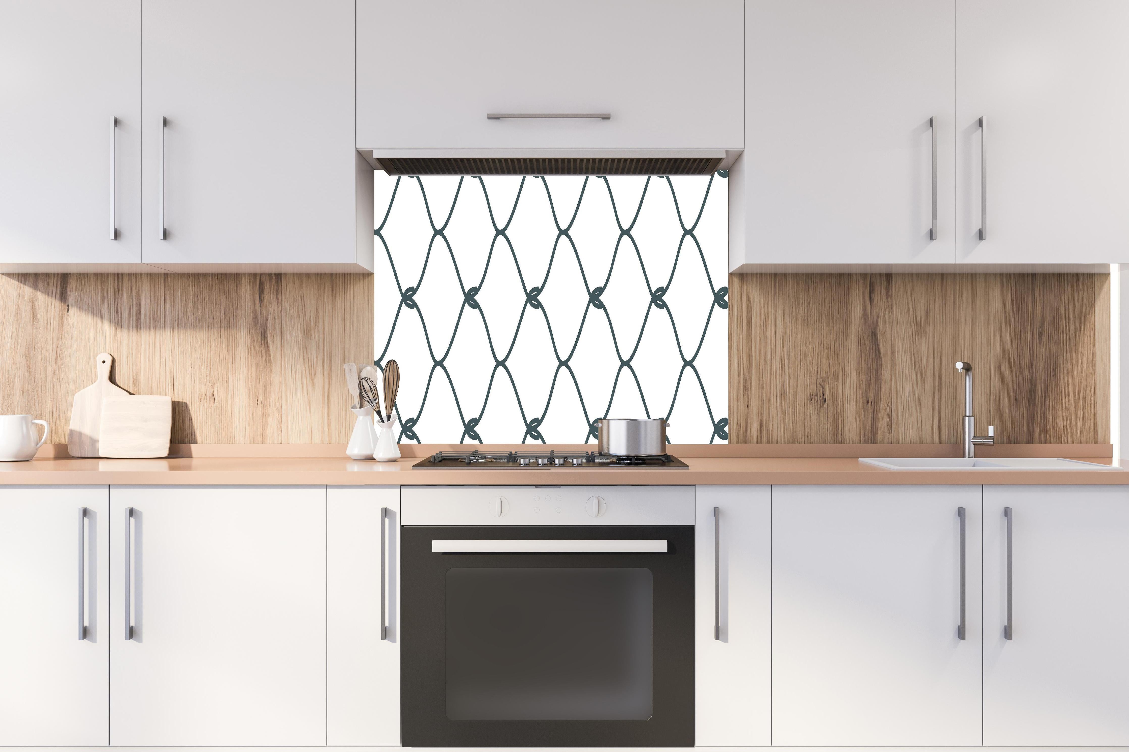 Spritzschutz - Robuster Maschendrahtzaun in Grau hinter einem Cerankochfeld zwischen Holz-Kochutensilien