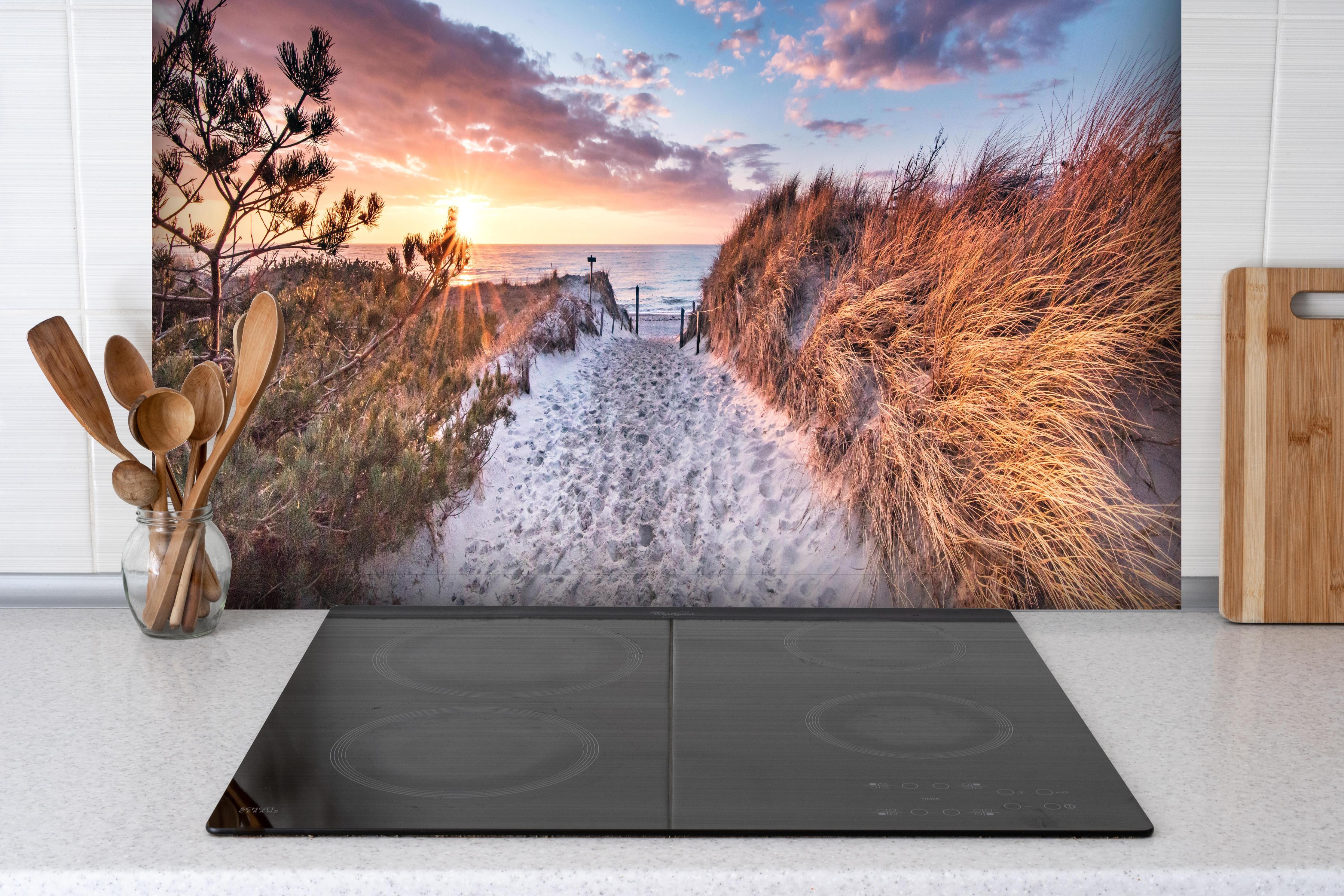 Spritzschutz - Romantischer Sandweg zum Strand hinter einem Cerankochfeld zwischen Holz-Kochutensilien