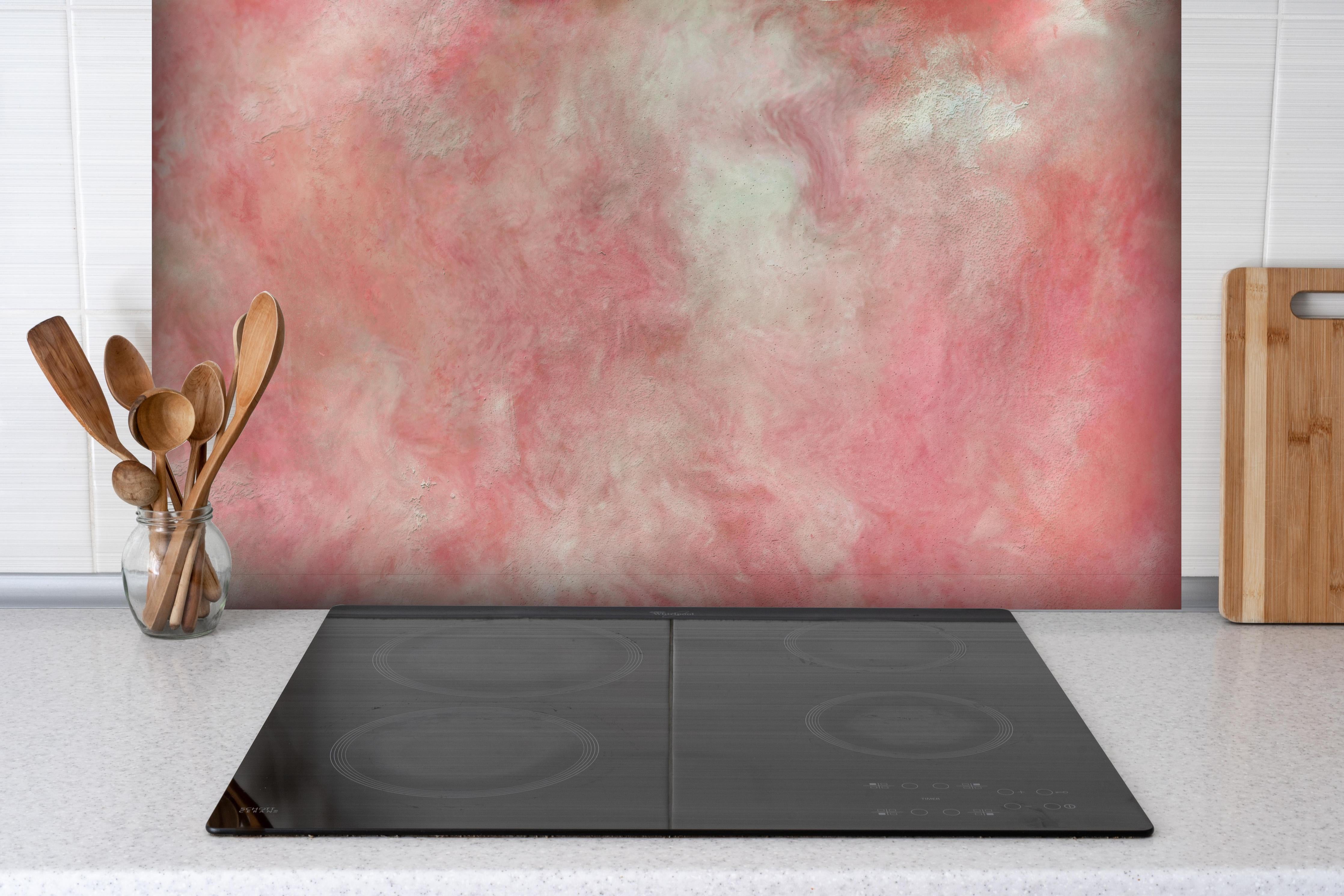 Spritzschutz - Rosa Marble Textur hinter einem Cerankochfeld zwischen Holz-Kochutensilien