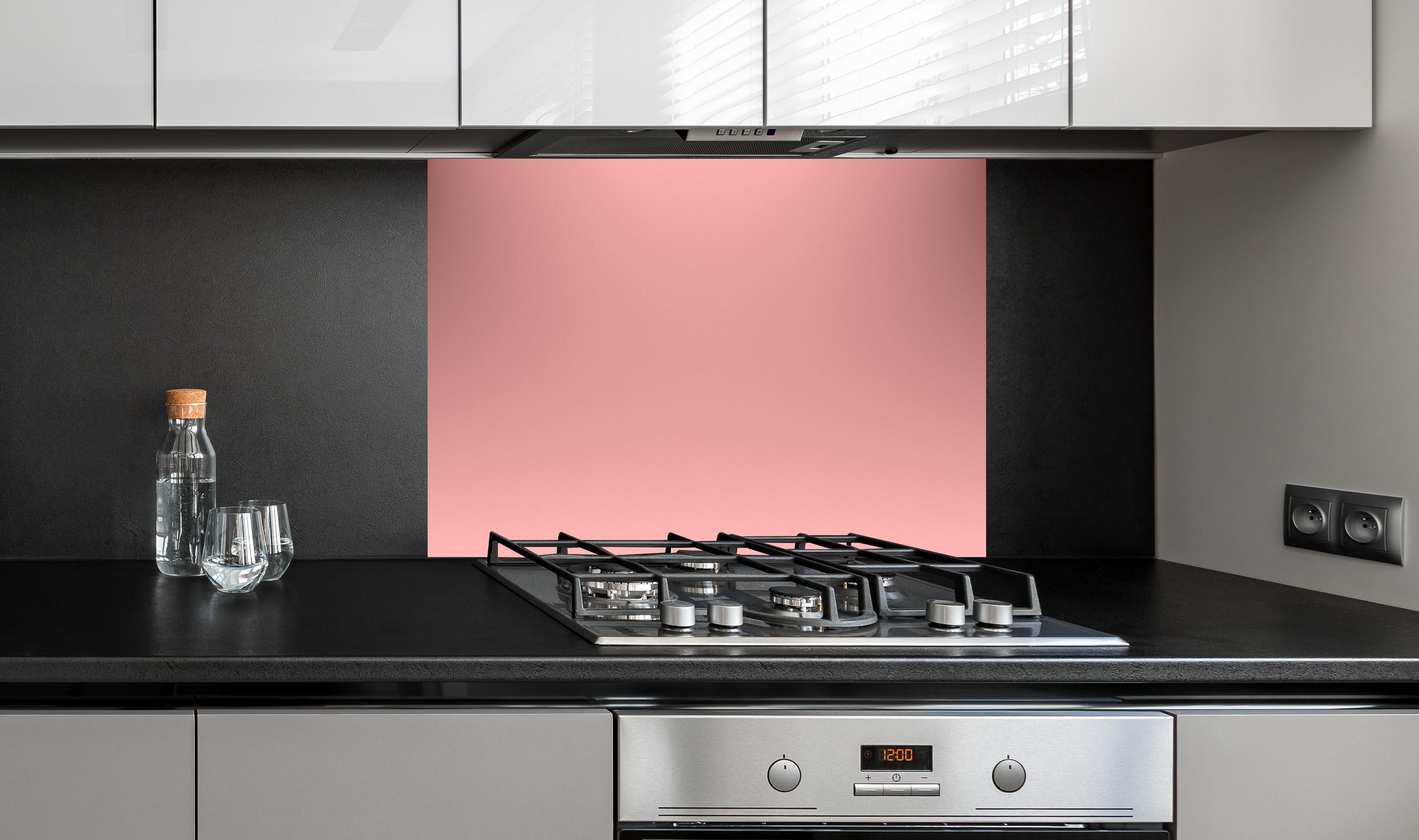 Spritzschutz - Rosa Oberfläche - Papiertextur hinter einem Cerankochfeld zwischen Holz-Kochutensilien