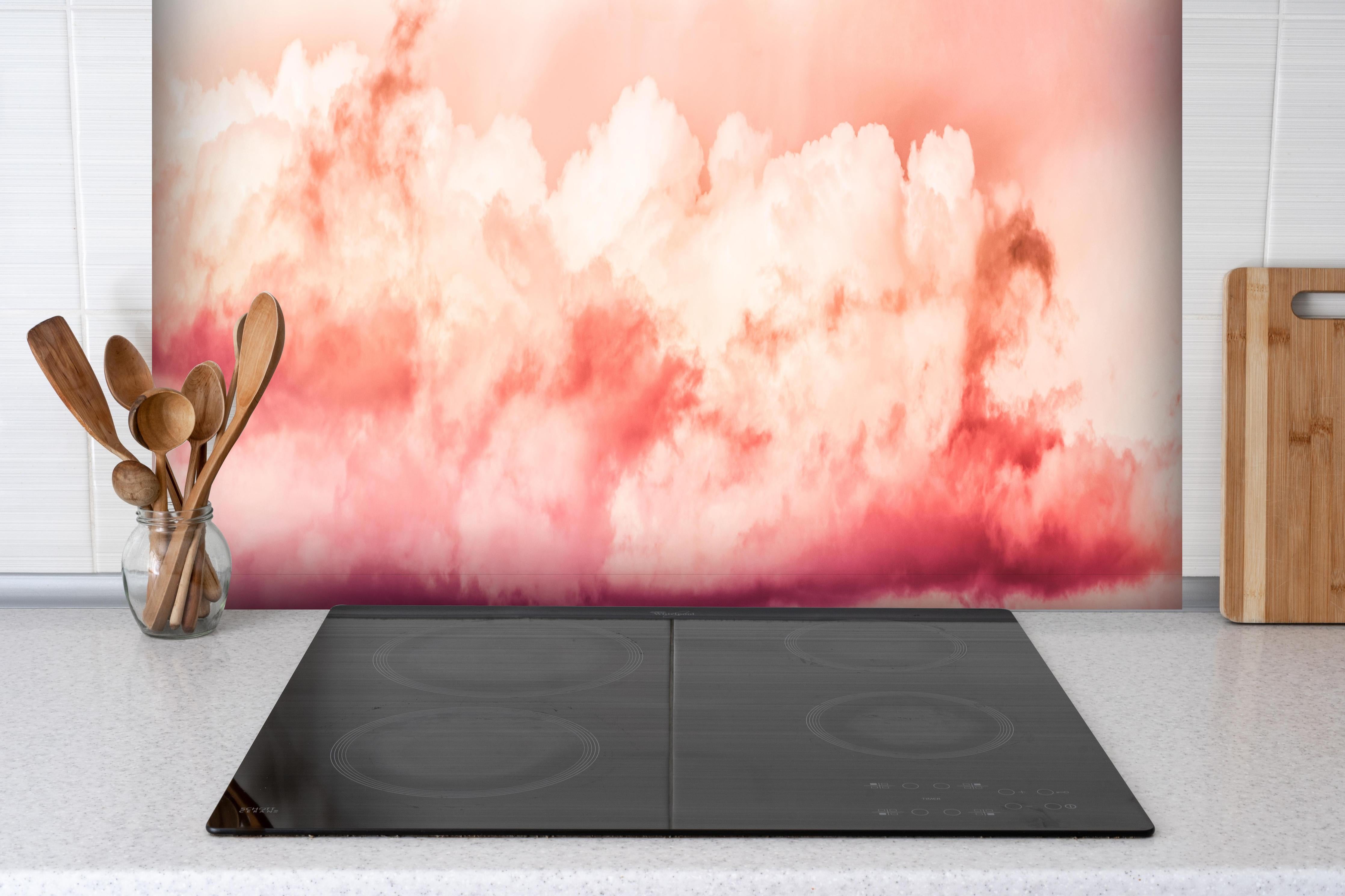 Spritzschutz - Rosa Wolkenhimmel hinter einem Cerankochfeld zwischen Holz-Kochutensilien