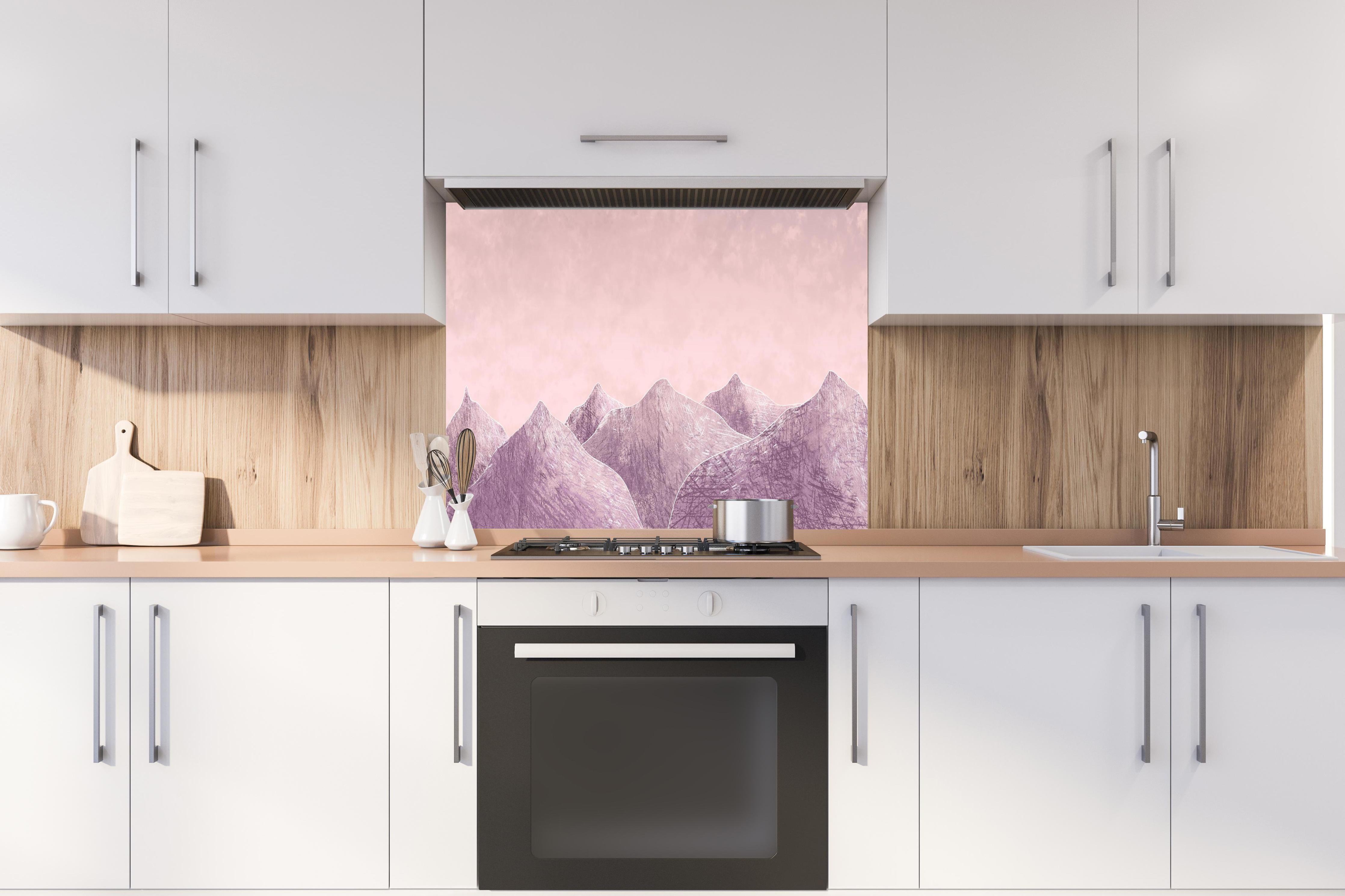 Spritzschutz - Rosa-lilane Berglandschaft - Kunstmalerei hinter einem Cerankochfeld zwischen Holz-Kochutensilien