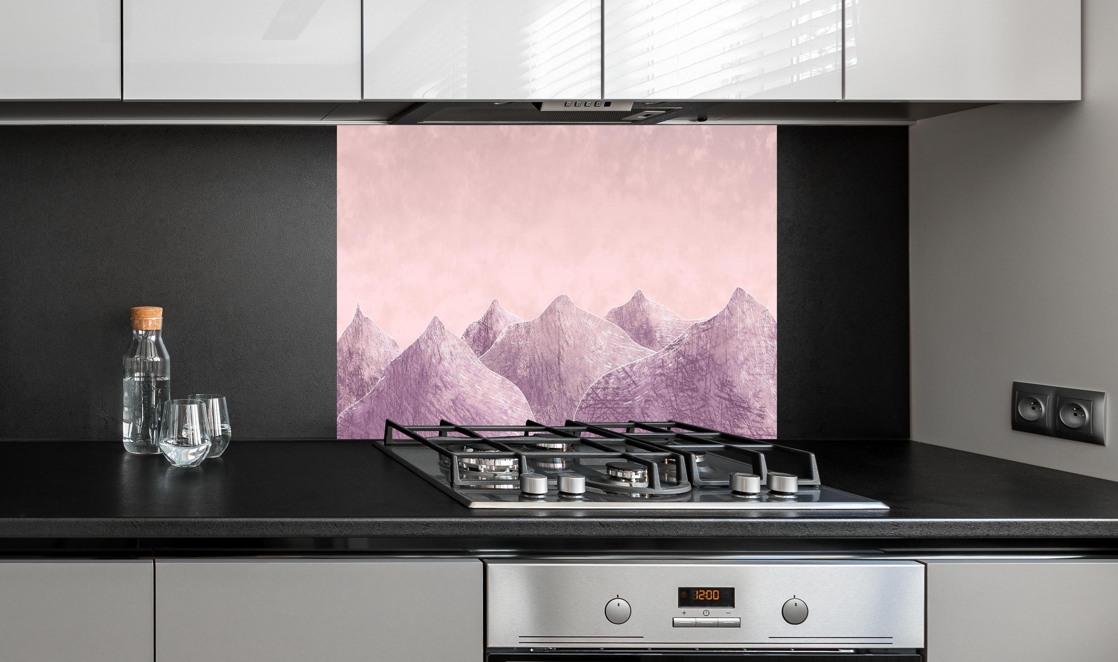 Spritzschutz - Rosa-lilane Berglandschaft - Kunstmalerei hinter einem Cerankochfeld zwischen Holz-Kochutensilien