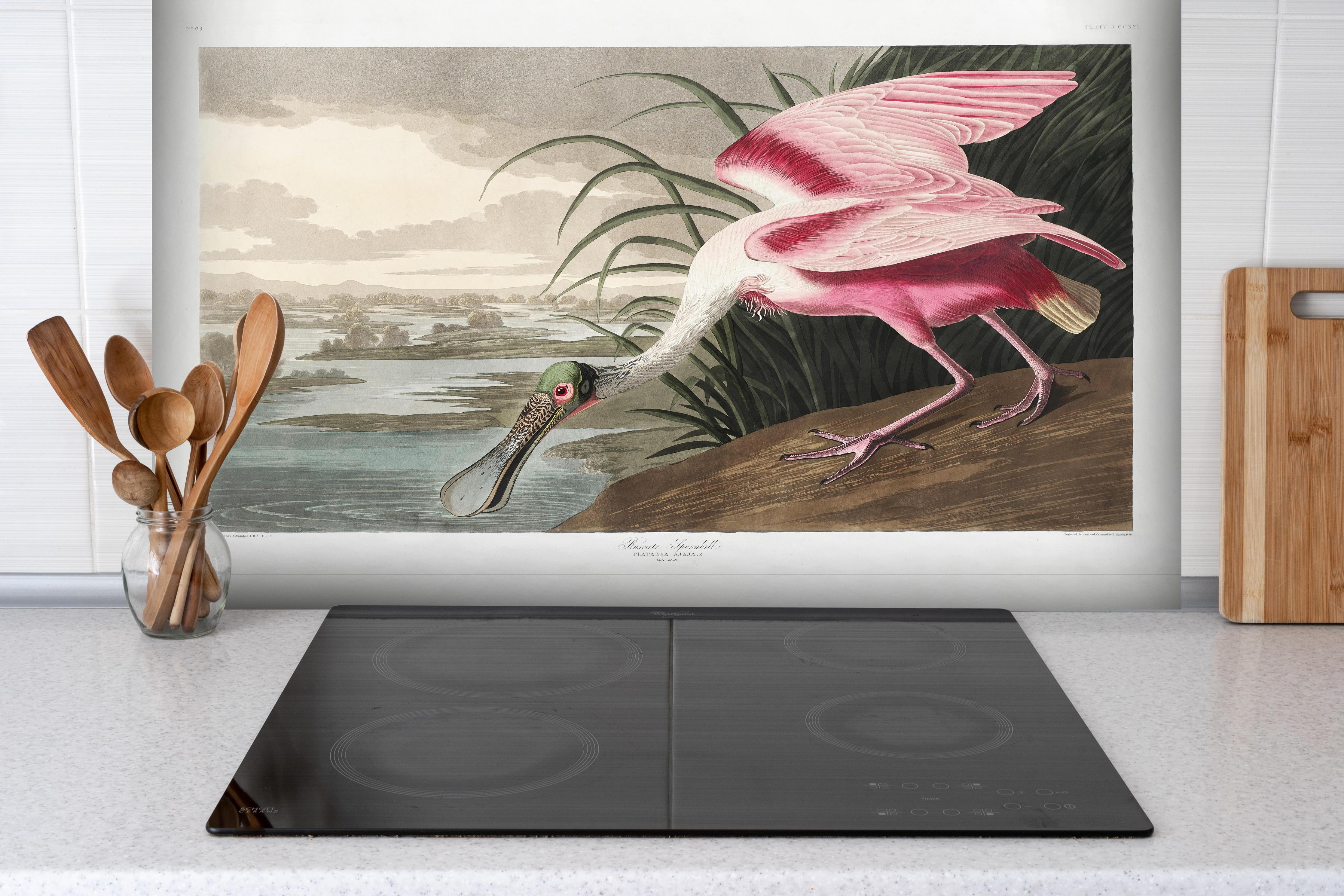 Spritzschutz - Rosalöffler hinter einem Cerankochfeld zwischen Holz-Kochutensilien