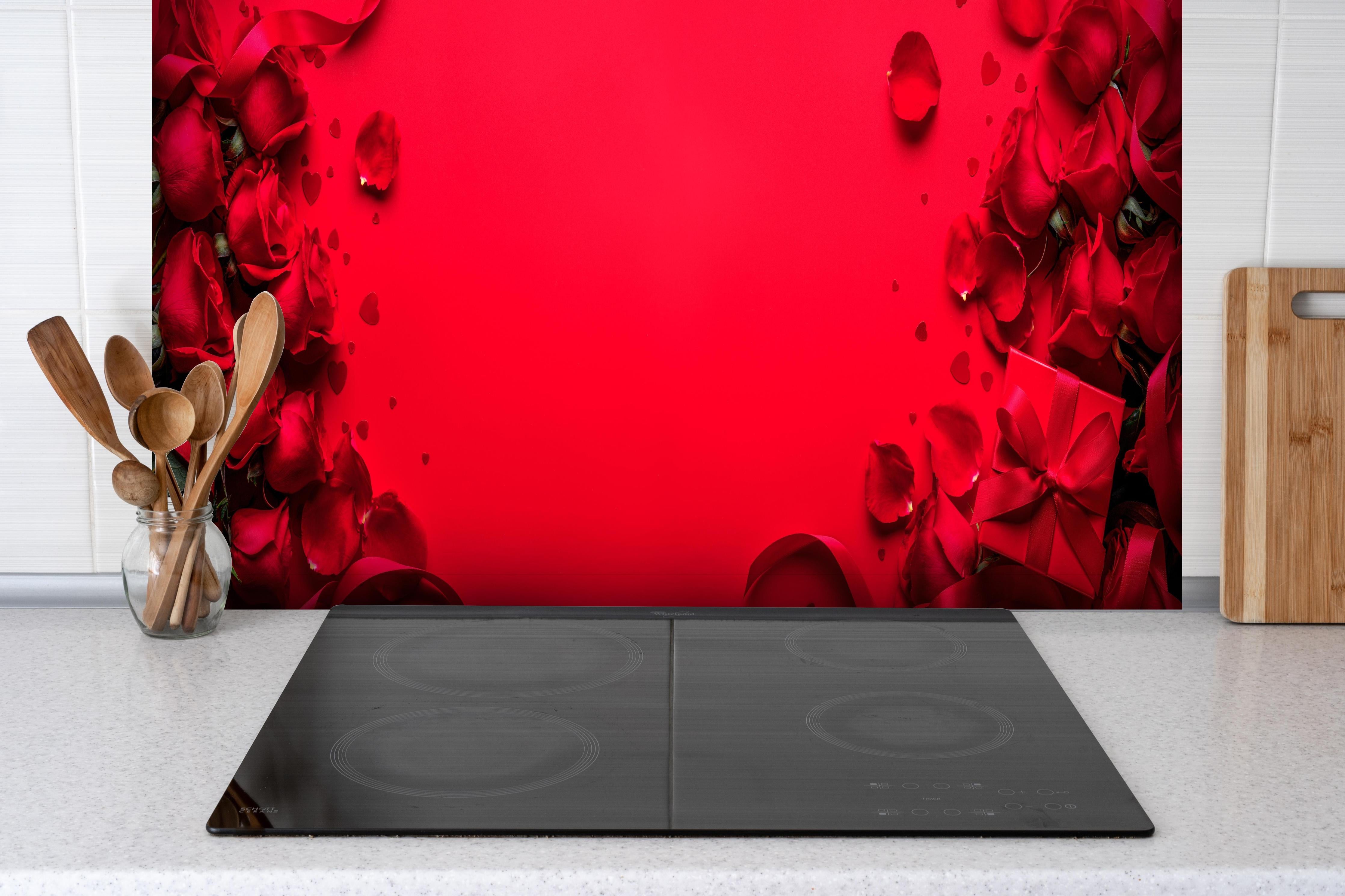 Spritzschutz - Rosengeschenk auf rotem Hintergrund hinter einem Cerankochfeld zwischen Holz-Kochutensilien