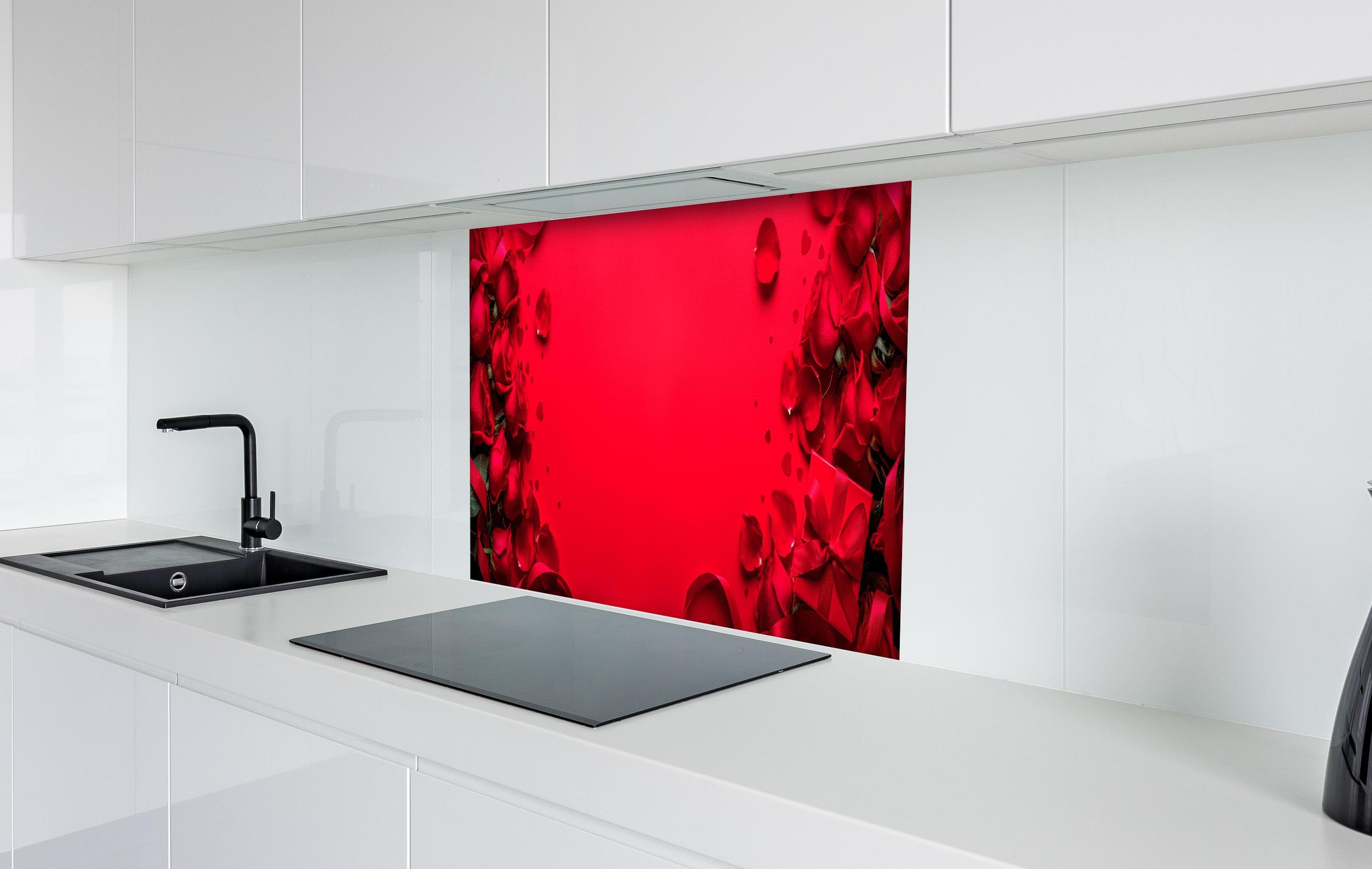 Spritzschutz - Rosengeschenk auf rotem Hintergrund hinter einem Cerankochfeld zwischen Holz-Kochutensilien