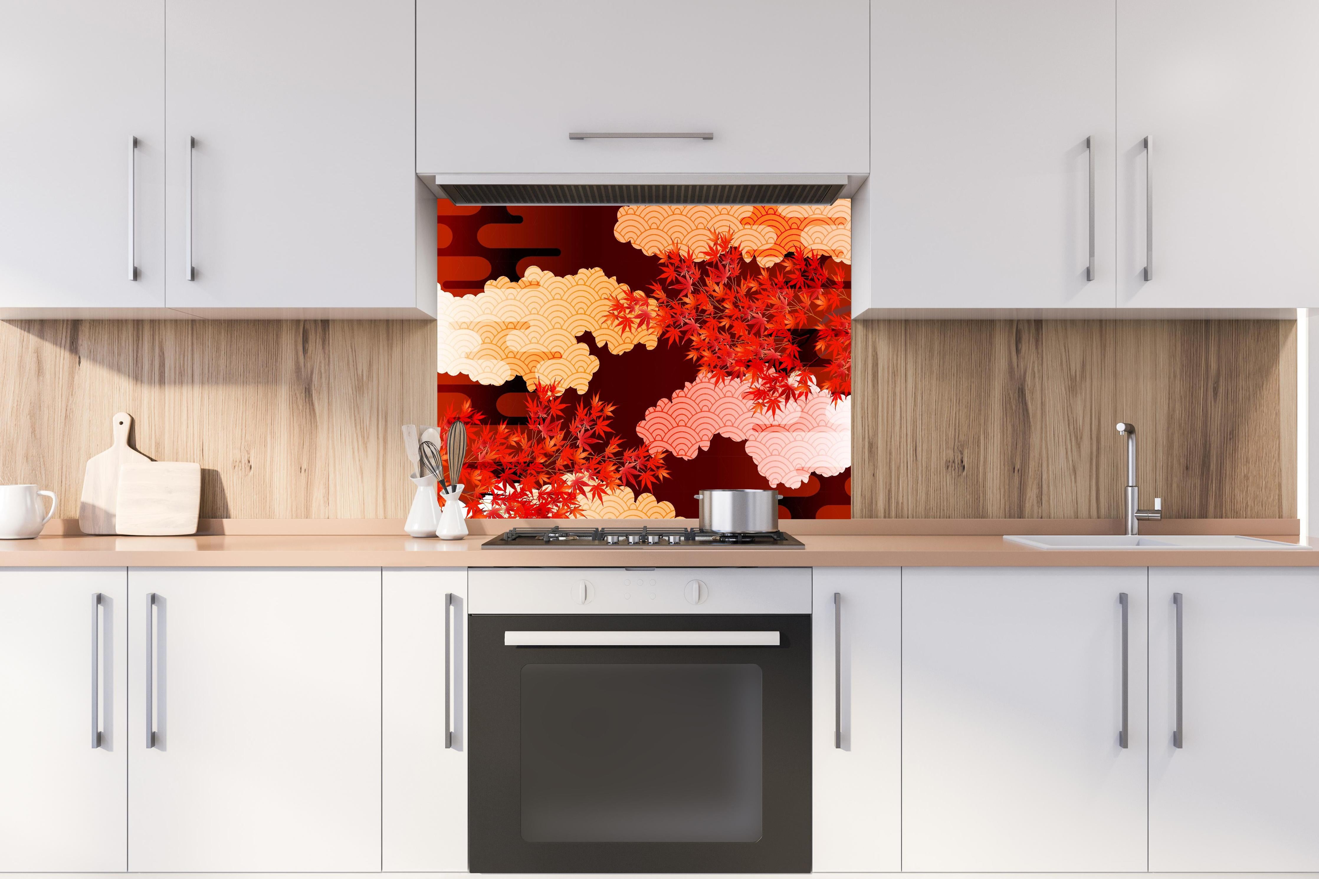 Spritzschutz - Rote Ahornblätter mit Wolkenmuster hinter einem Cerankochfeld zwischen Holz-Kochutensilien
