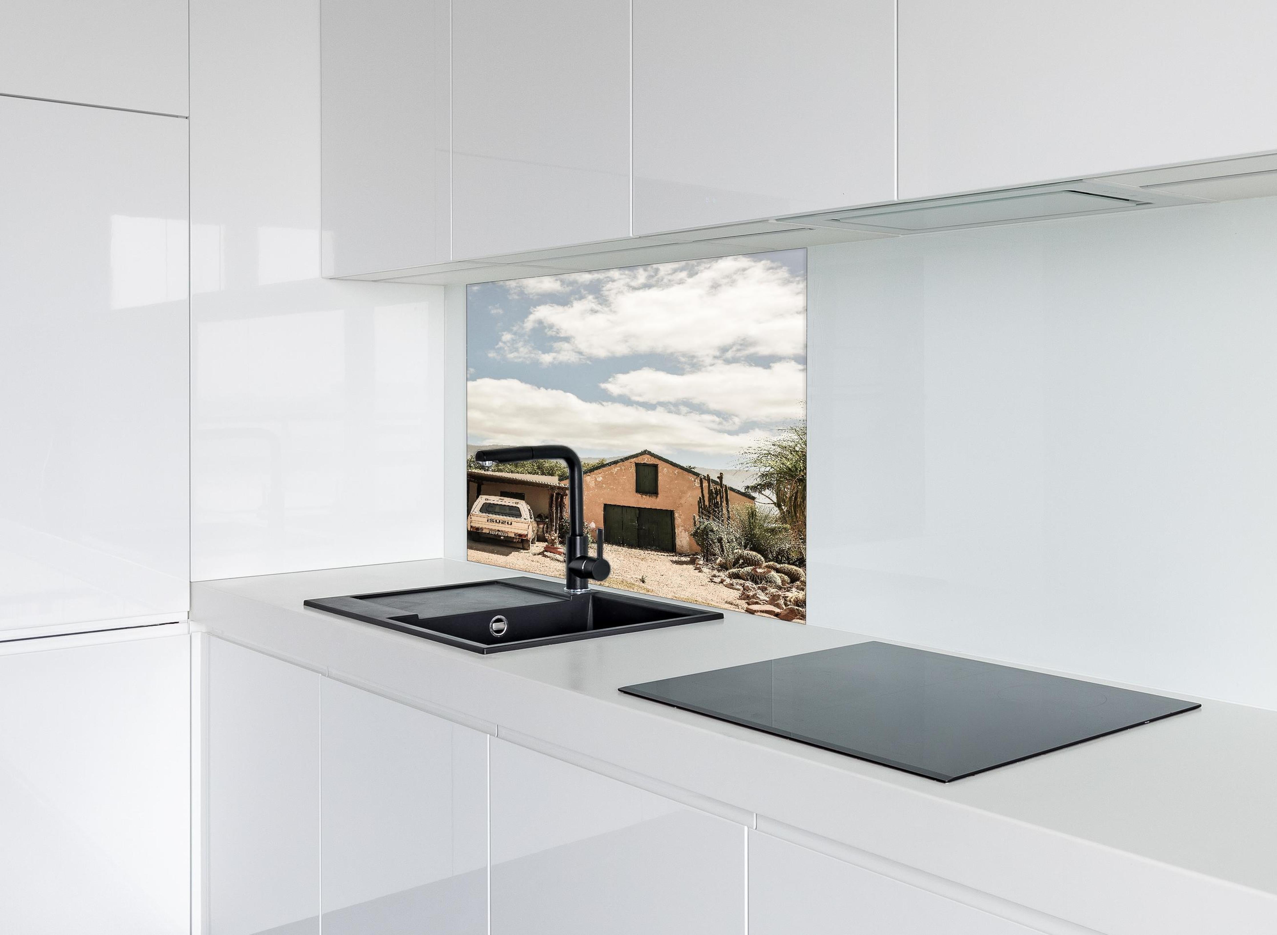 Spritzschutz - Rustikales Farmhaus Karoo in Ocker-Gelbtönen hinter einem Cerankochfeld zwischen Holz-Kochutensilien