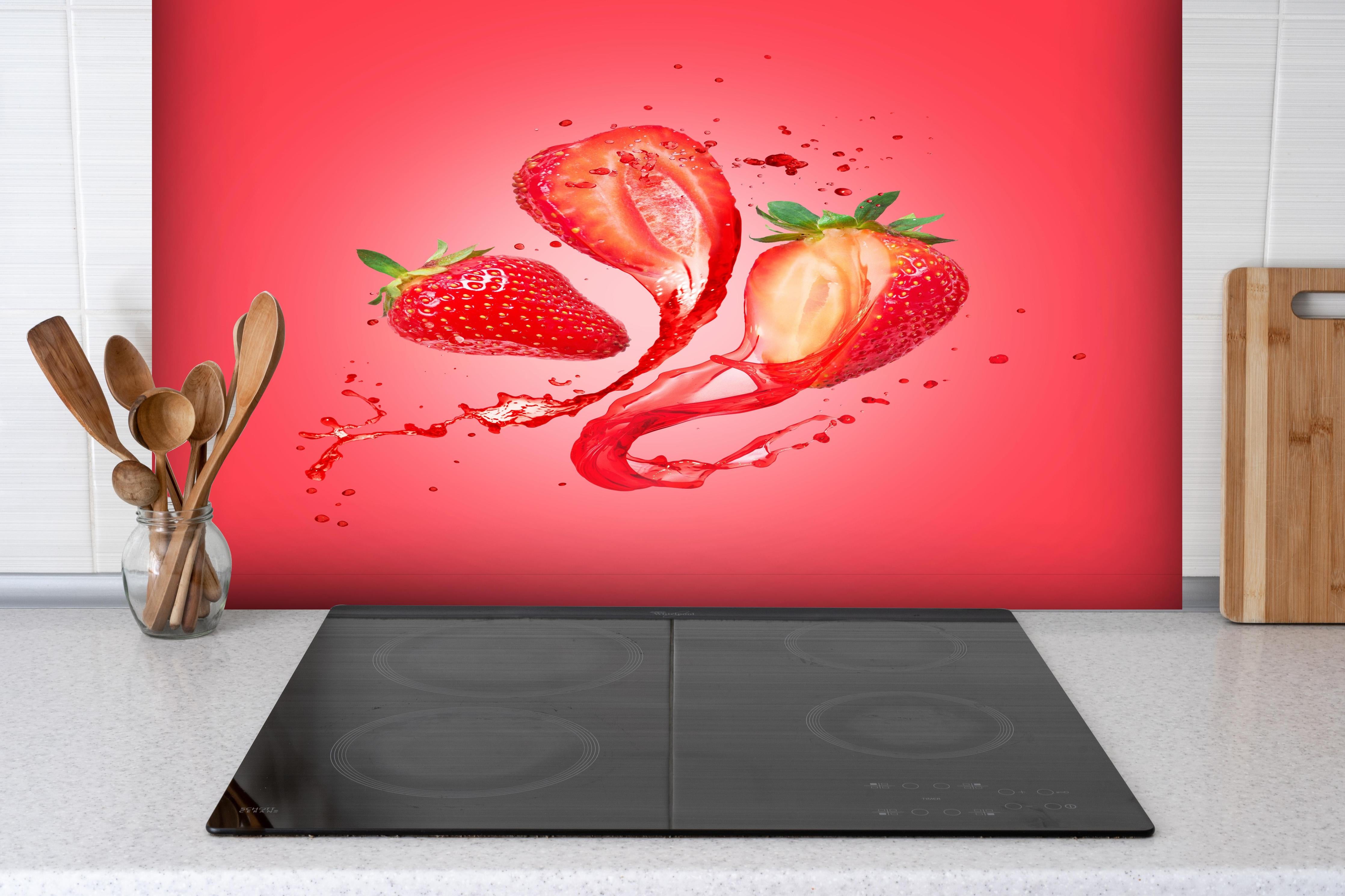 Spritzschutz - Saftige Erdbeeren hinter einem Cerankochfeld zwischen Holz-Kochutensilien
