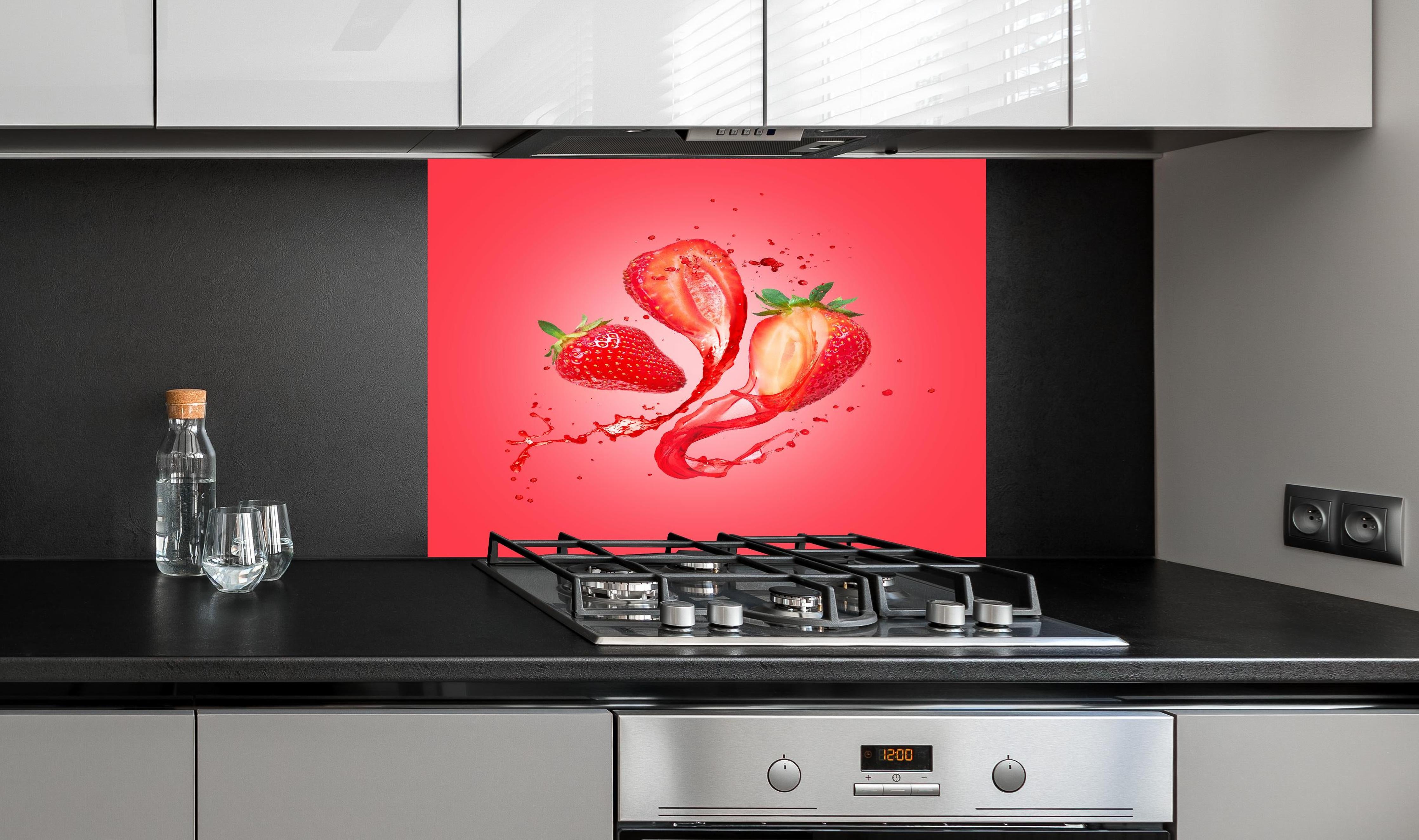 Spritzschutz - Saftige Erdbeeren hinter einem Cerankochfeld zwischen Holz-Kochutensilien