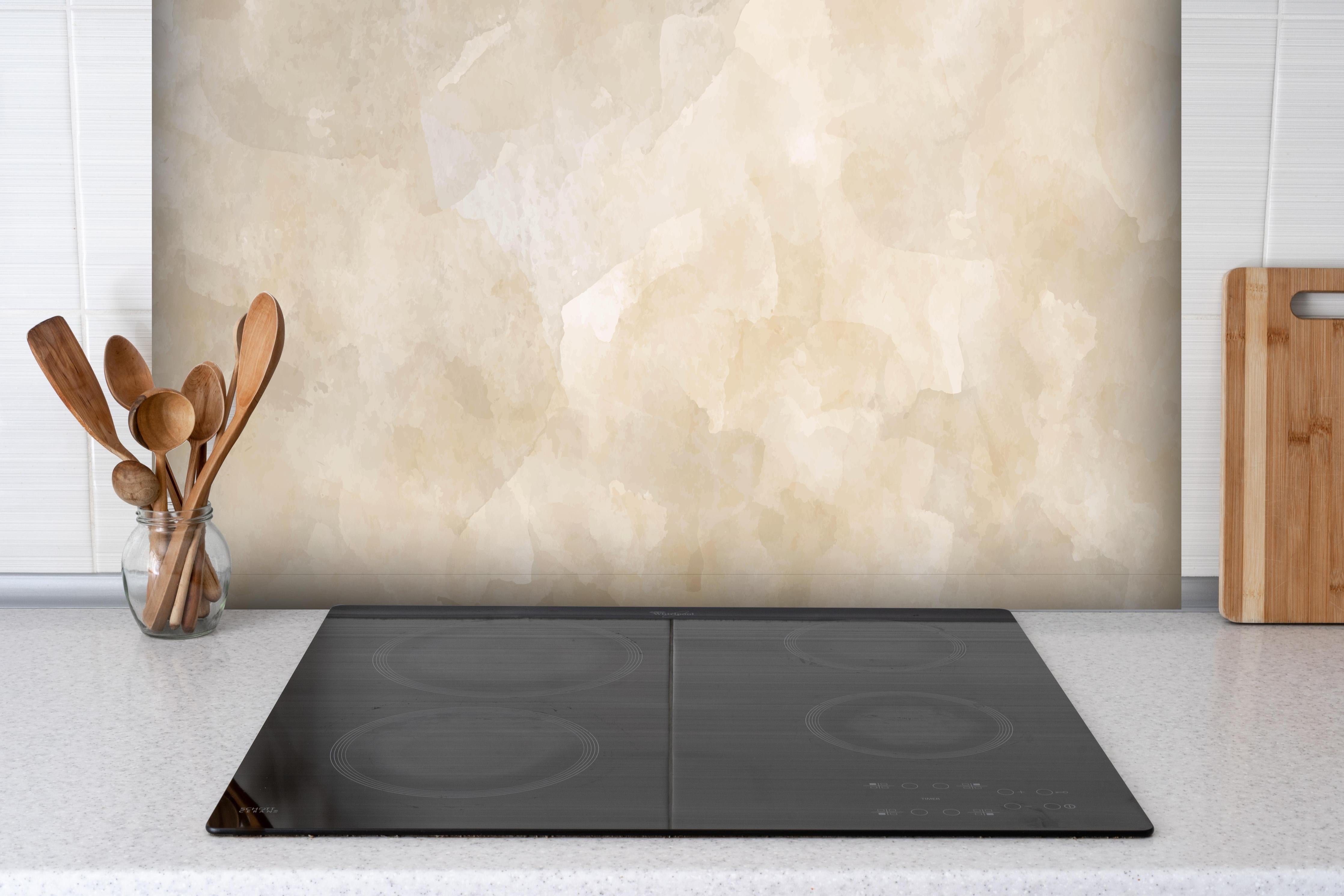 Spritzschutz - Sanfte Beige-Creme Marmoroptik Texture hinter einem Cerankochfeld zwischen Holz-Kochutensilien