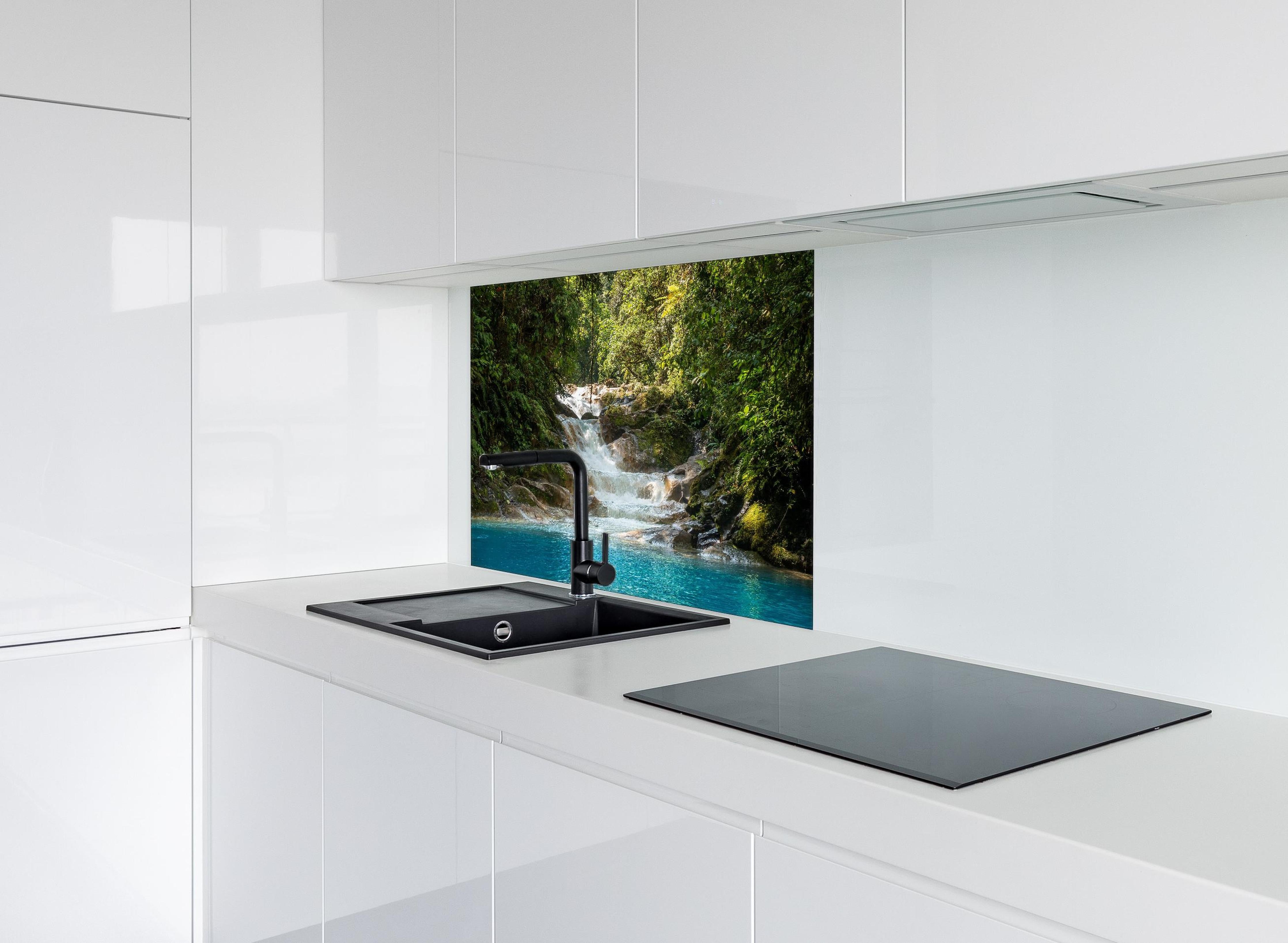 Spritzschutz - Sanfter Wasserfall im grünen Dschungel hinter einem Cerankochfeld zwischen Holz-Kochutensilien