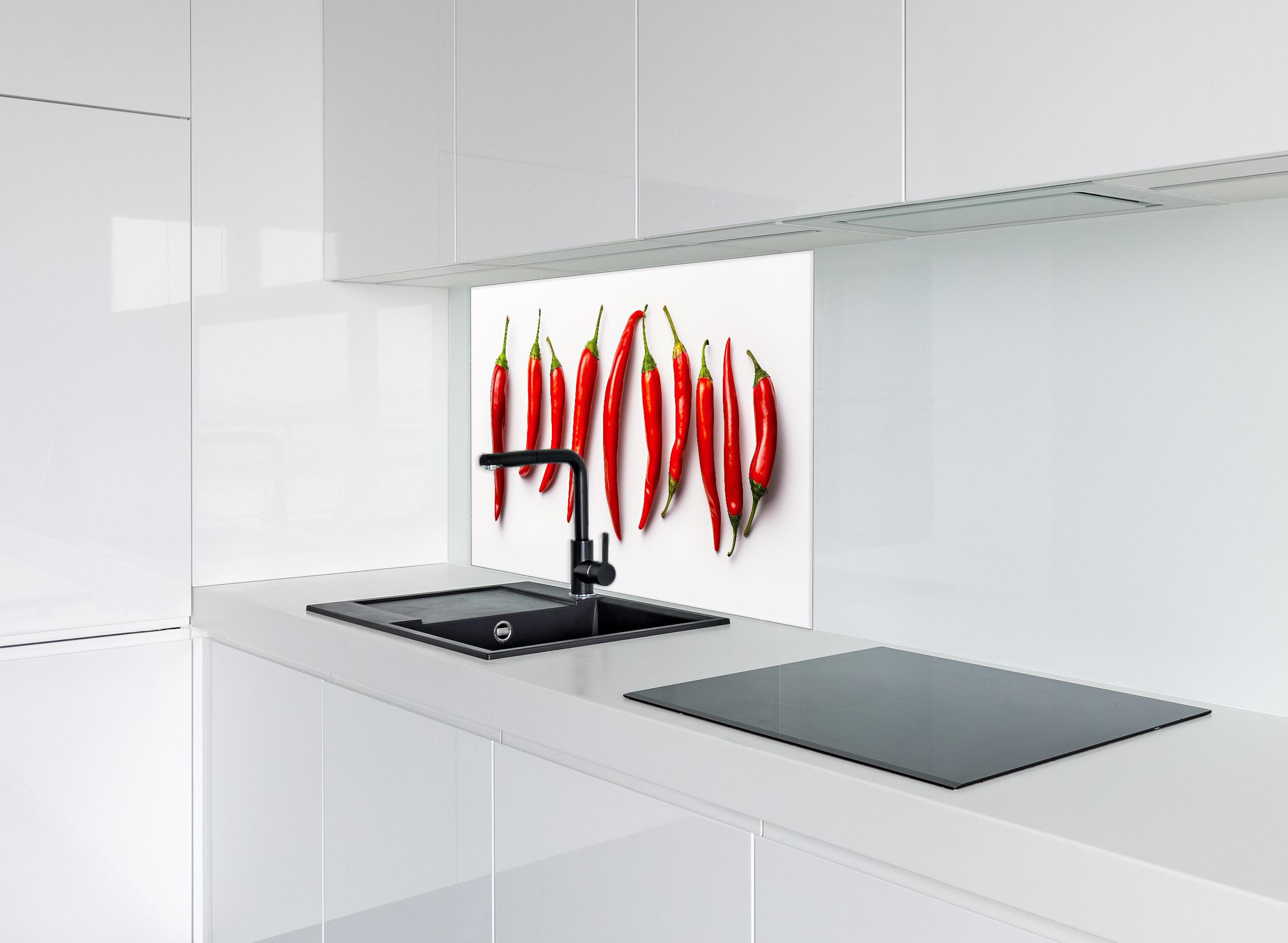 Spritzschutz - Scharfe Rote Chili Schoten im Überblick hinter einem Cerankochfeld zwischen Holz-Kochutensilien