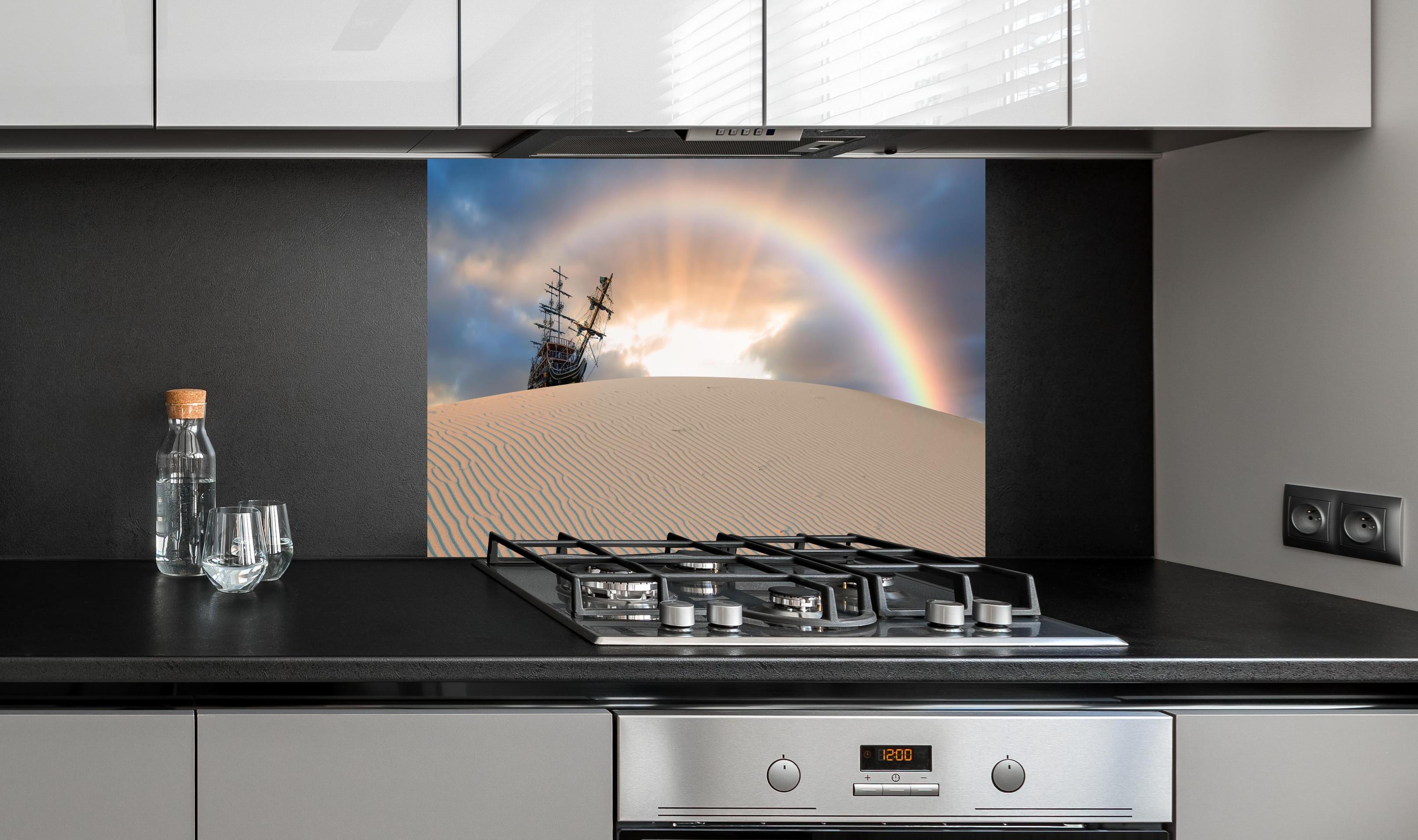 Spritzschutz - Schiff in Wüste mit Regenbogen bei Sonnenuntergang hinter einem Cerankochfeld zwischen Holz-Kochutensilien