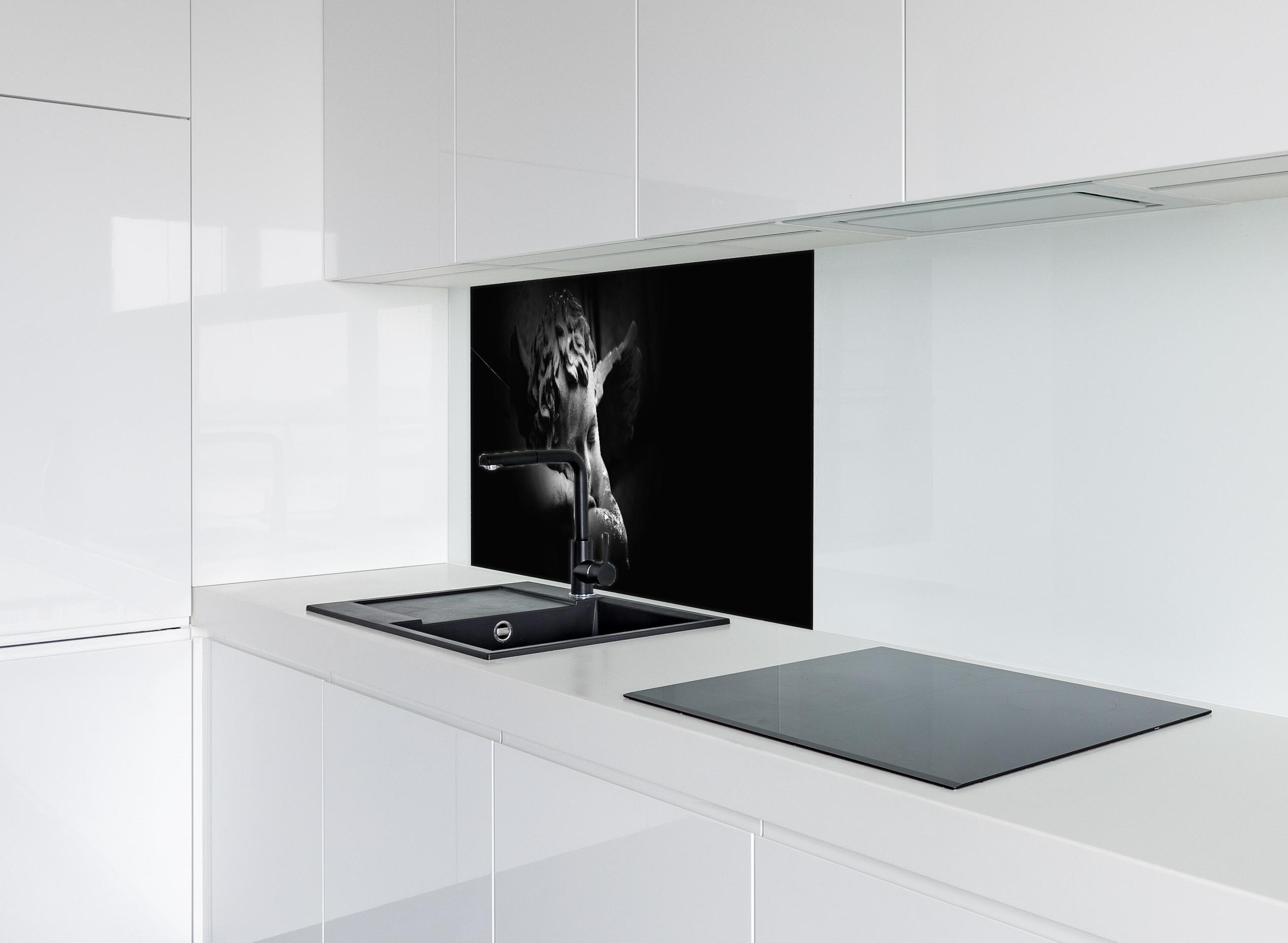 Spritzschutz - Schlafender Engel Statue in Schwarz-Weiß hinter einem Cerankochfeld zwischen Holz-Kochutensilien