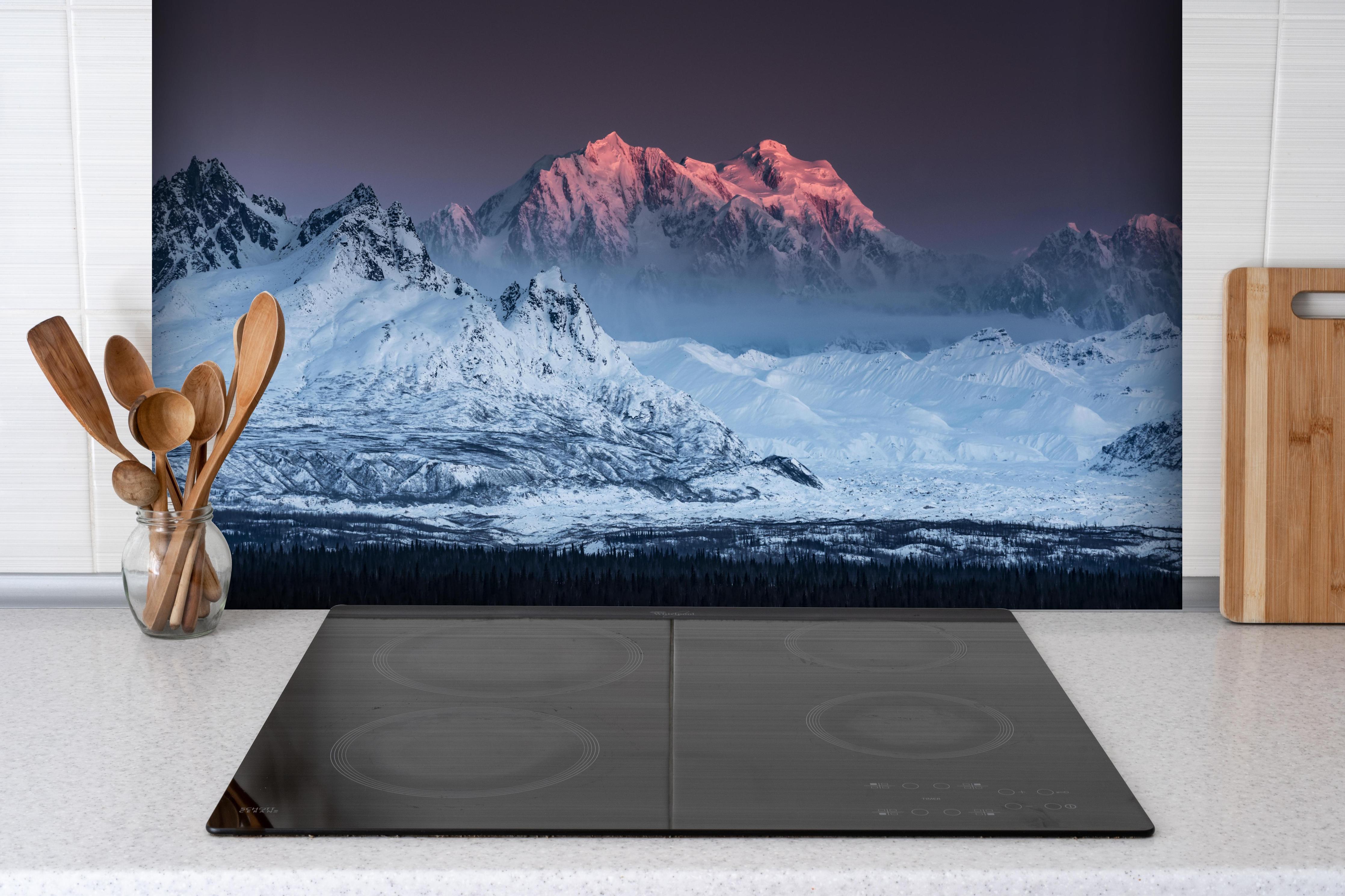 Spritzschutz - Schneebedeckte Gipfel Alaskas bei Sonnenuntergang hinter einem Cerankochfeld zwischen Holz-Kochutensilien