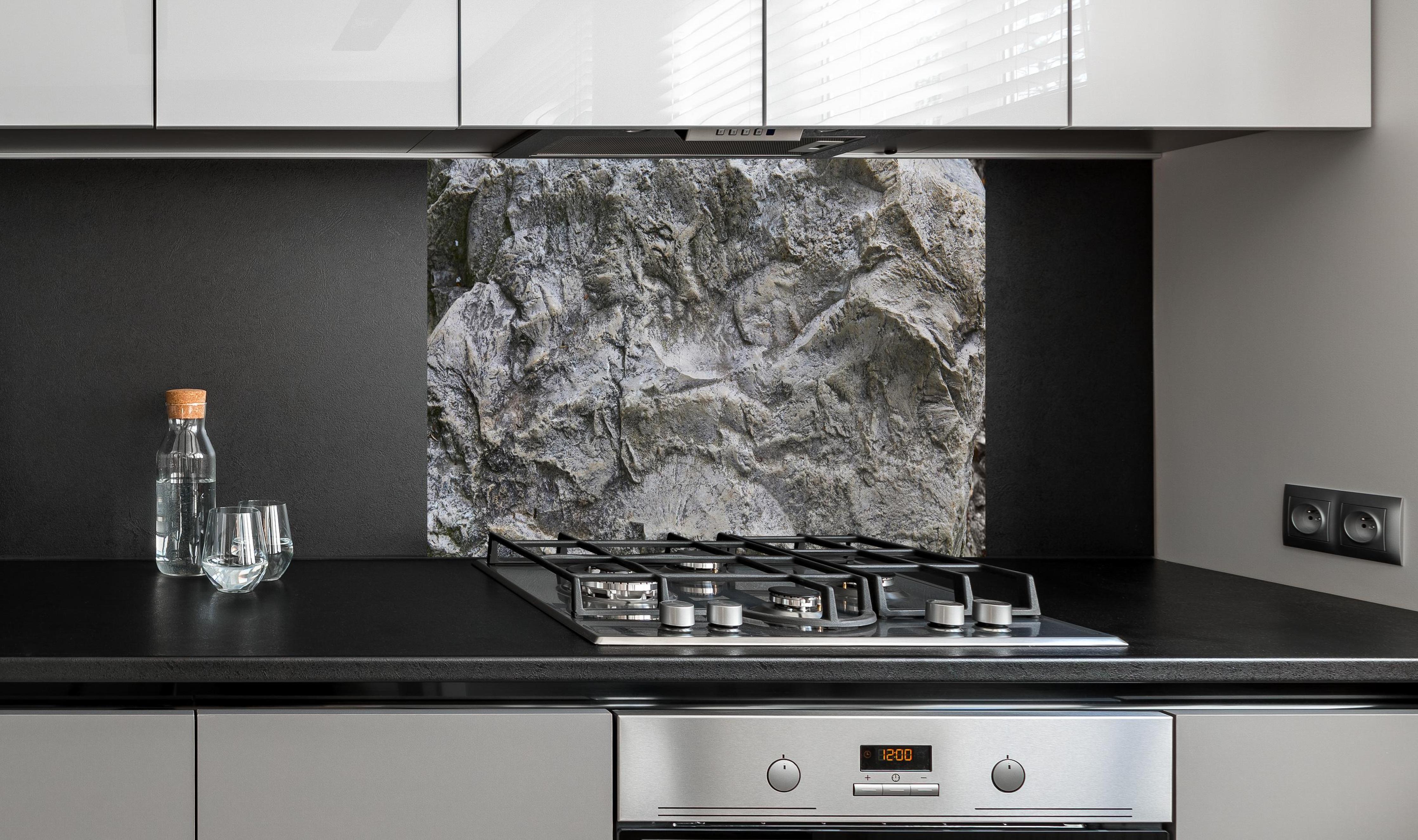 Spritzschutz - Schöne Felsstruktur - Granit hinter einem Cerankochfeld zwischen Holz-Kochutensilien