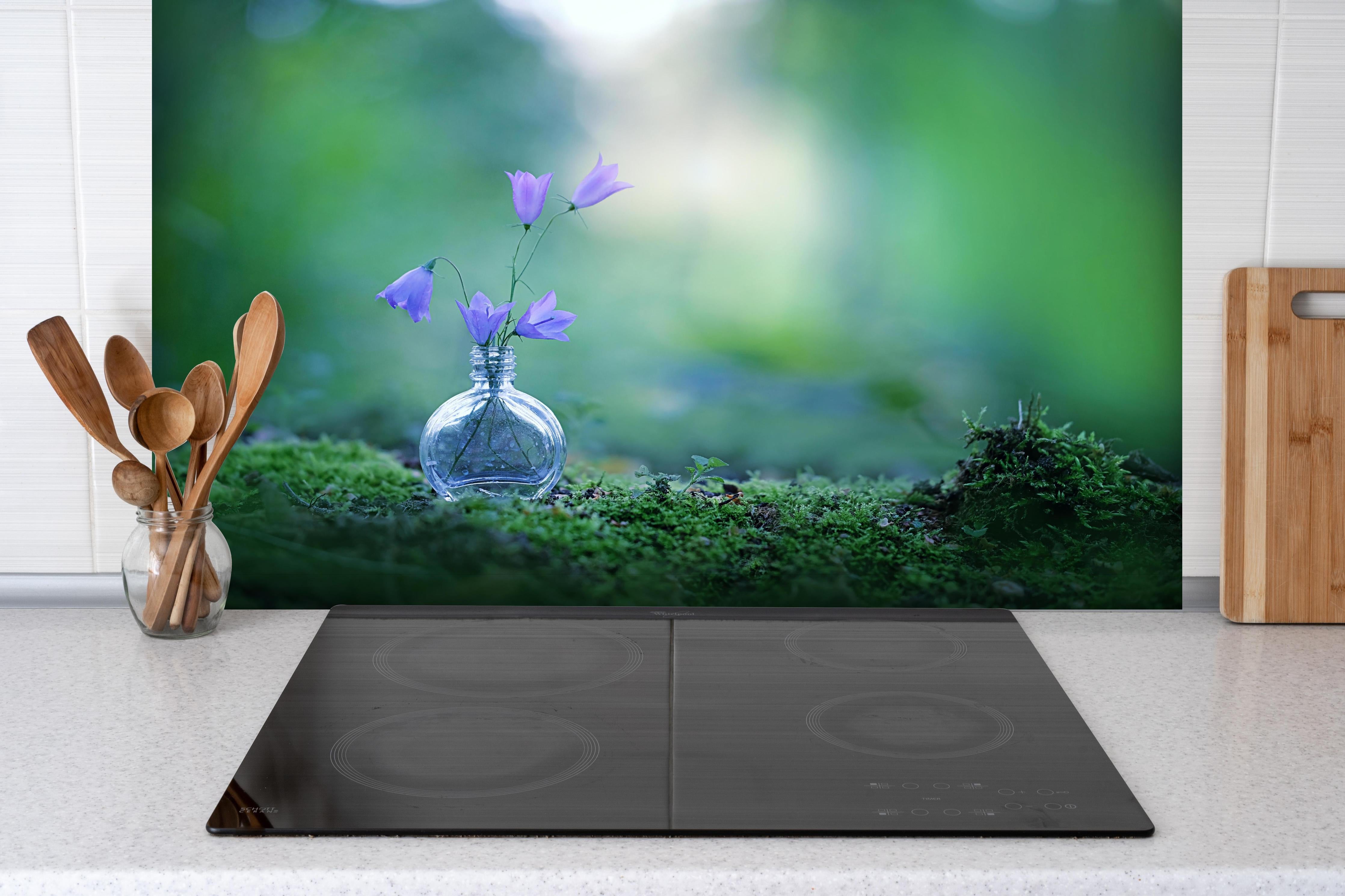 Spritzschutz - Schöne campanula Blumen hinter einem Cerankochfeld zwischen Holz-Kochutensilien