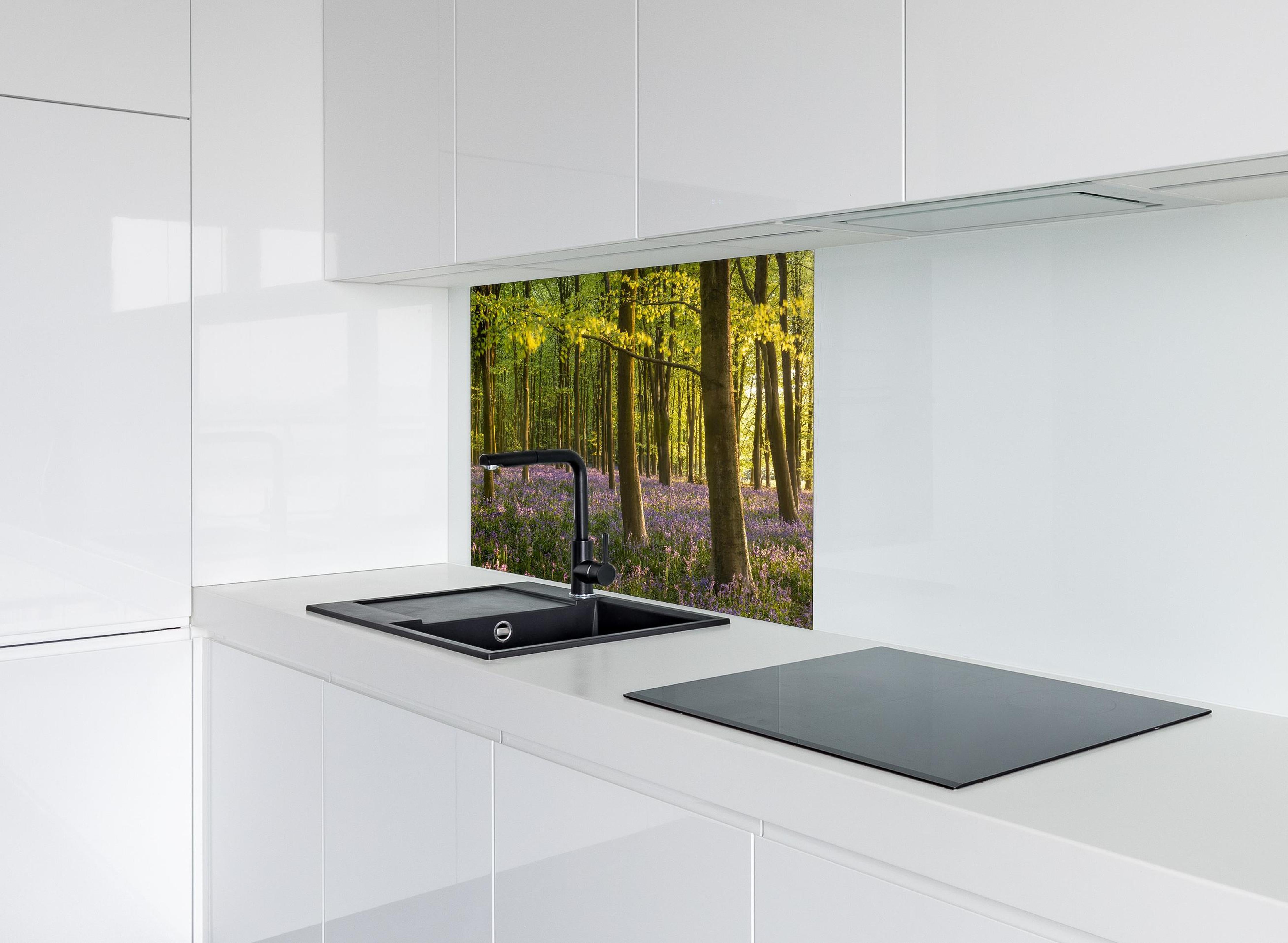 Spritzschutz - Schöner Blauglockenwald hinter einem Cerankochfeld zwischen Holz-Kochutensilien