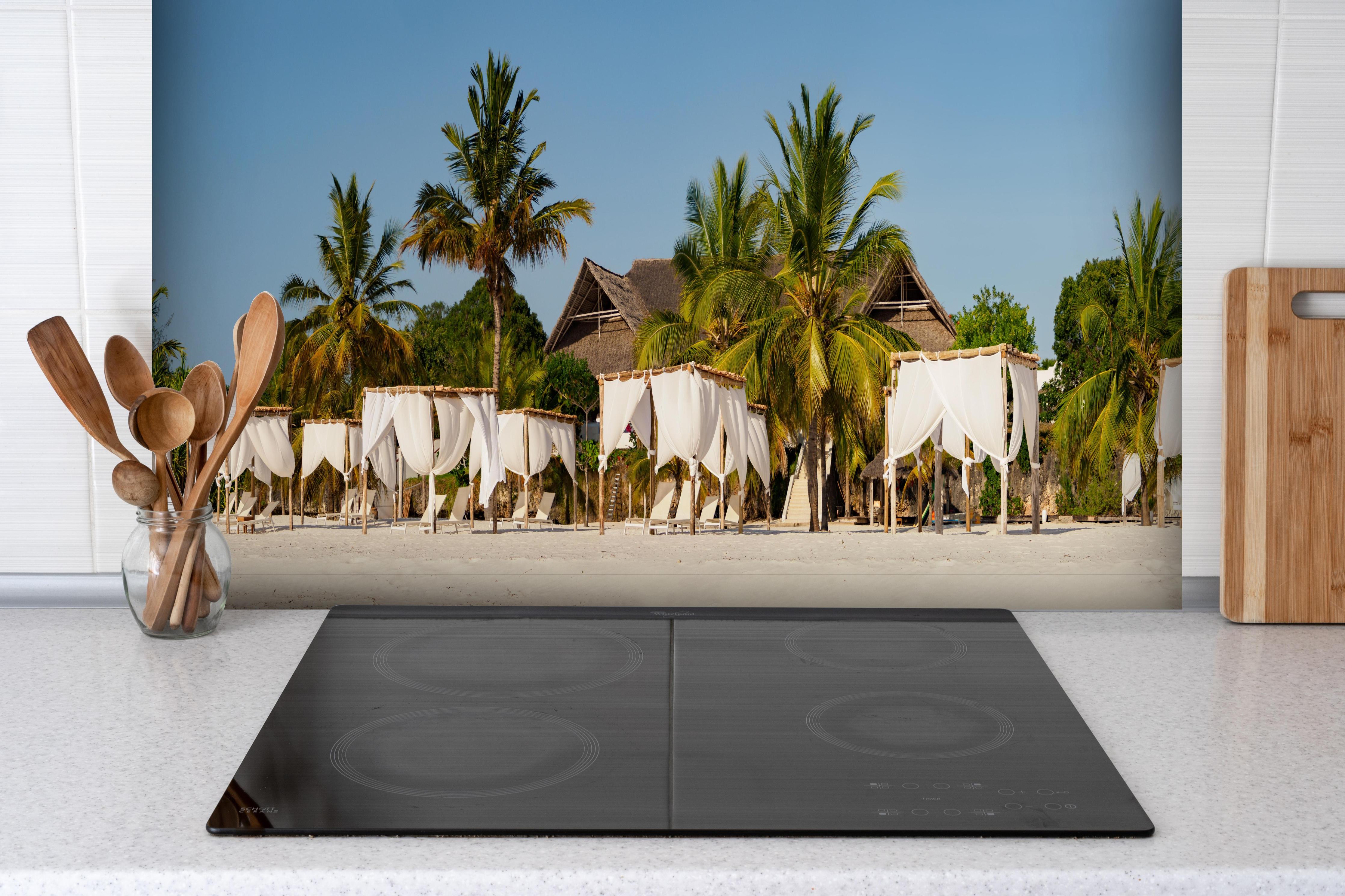 Spritzschutz - Schöner Strand mit Liegen hinter einem Cerankochfeld zwischen Holz-Kochutensilien