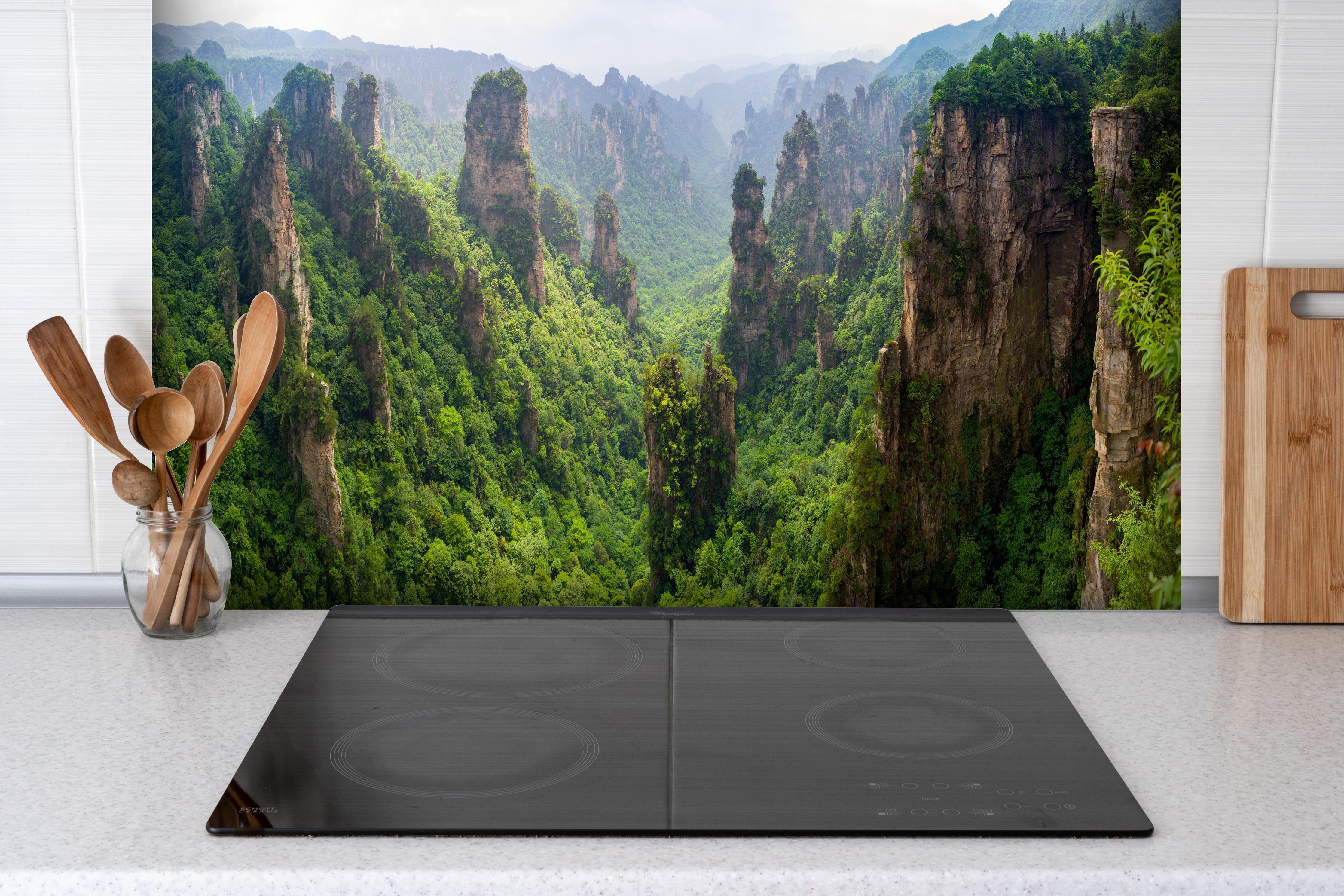 Spritzschutz - Schönes Panorama der Karstberge hinter einem Cerankochfeld zwischen Holz-Kochutensilien