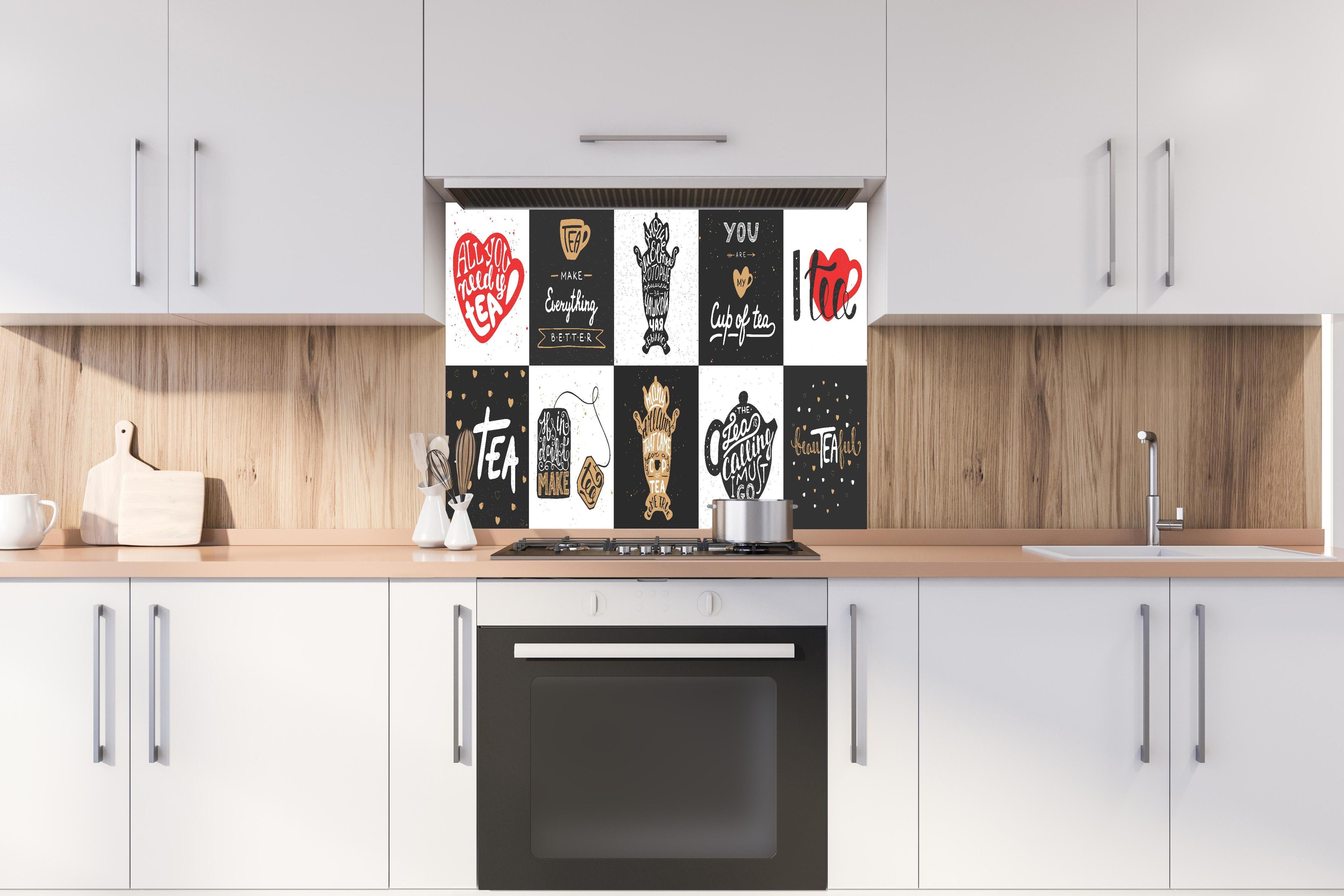 Spritzschutz - Schriftzug Sammlung für Tee Enthusiasten hinter einem Cerankochfeld zwischen Holz-Kochutensilien