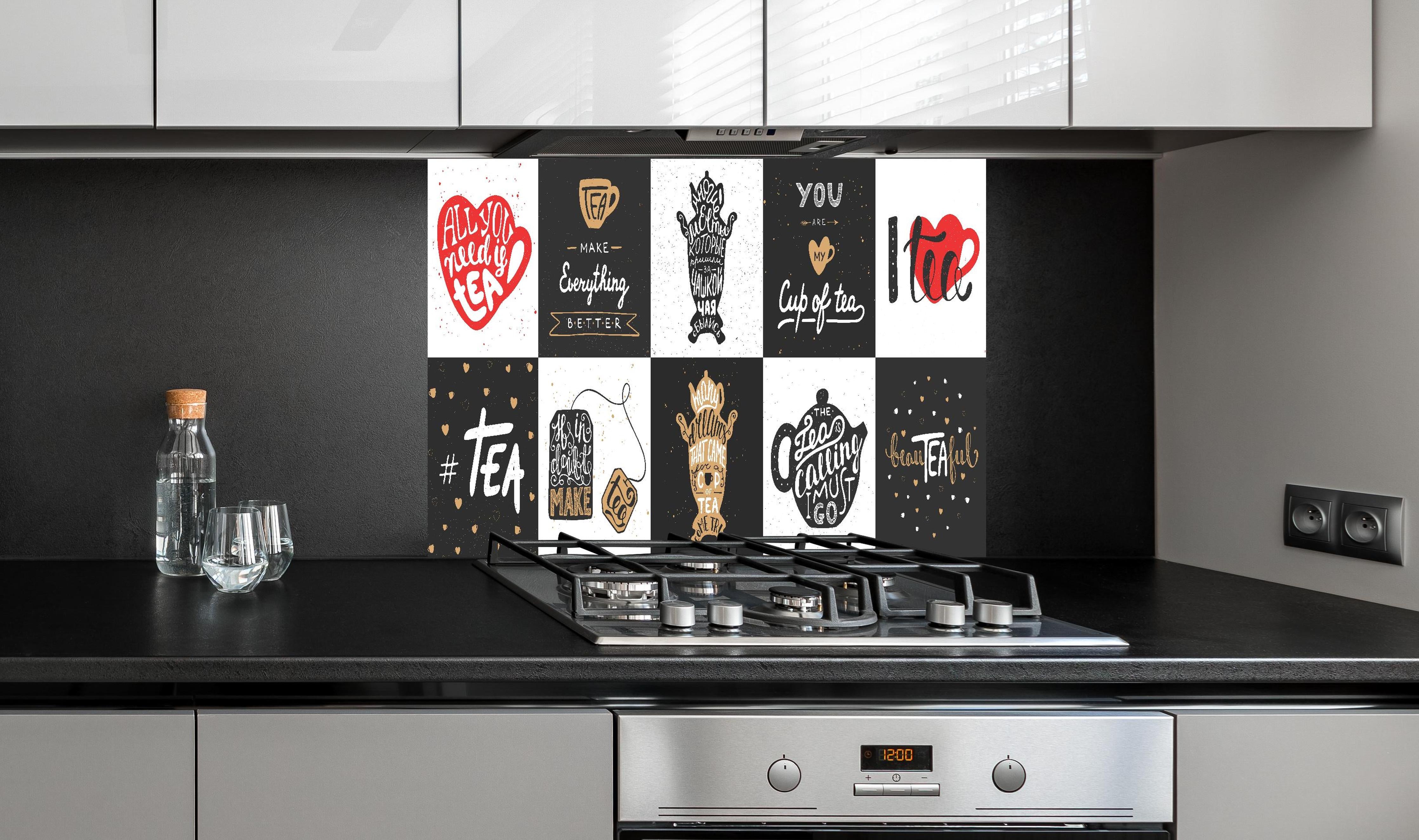 Spritzschutz - Schriftzug Sammlung für Tee Enthusiasten hinter einem Cerankochfeld zwischen Holz-Kochutensilien