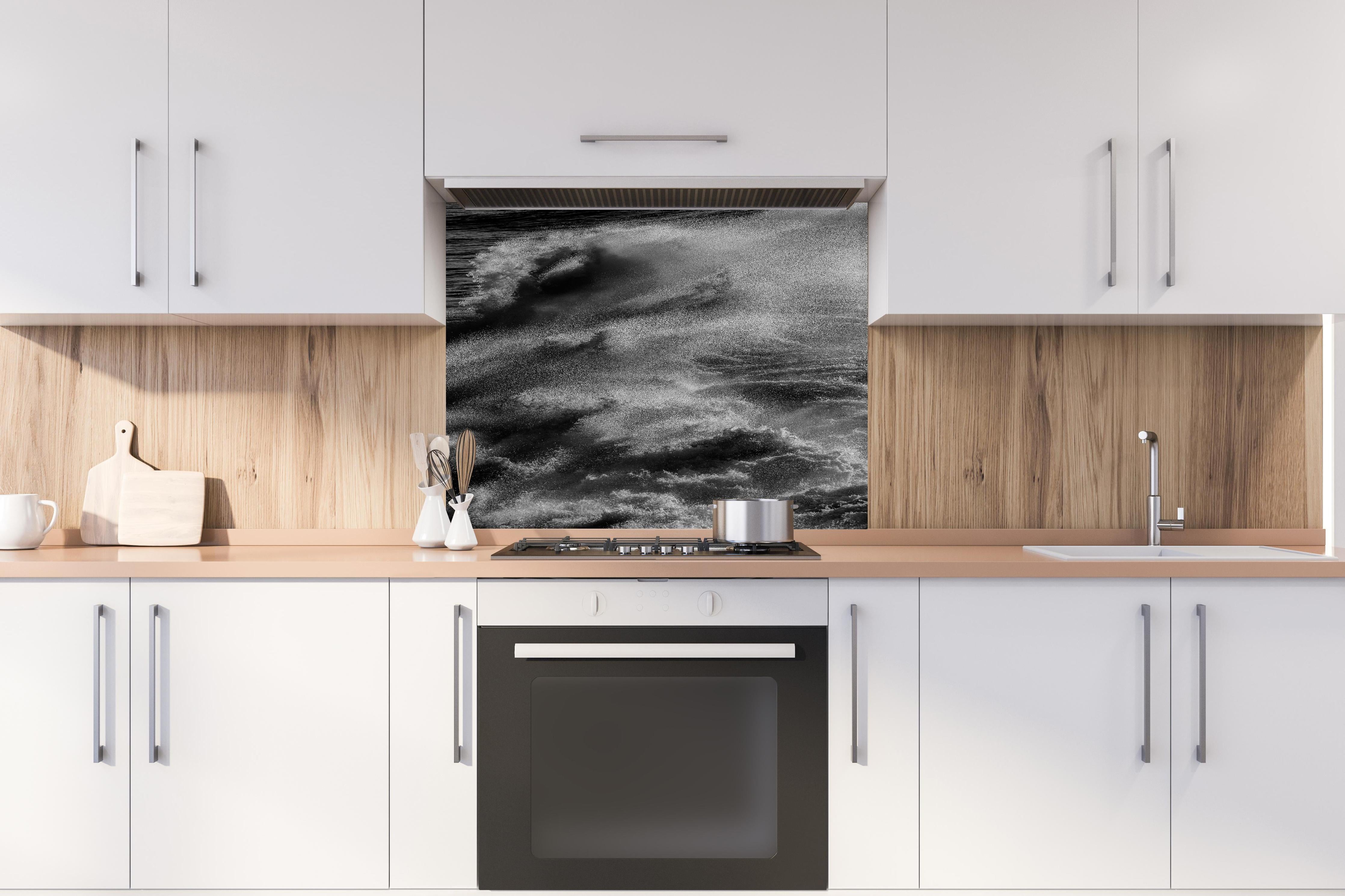 Spritzschutz - Schwarz-Weiße Ozeanwellen-Abstraktion hinter einem Cerankochfeld zwischen Holz-Kochutensilien