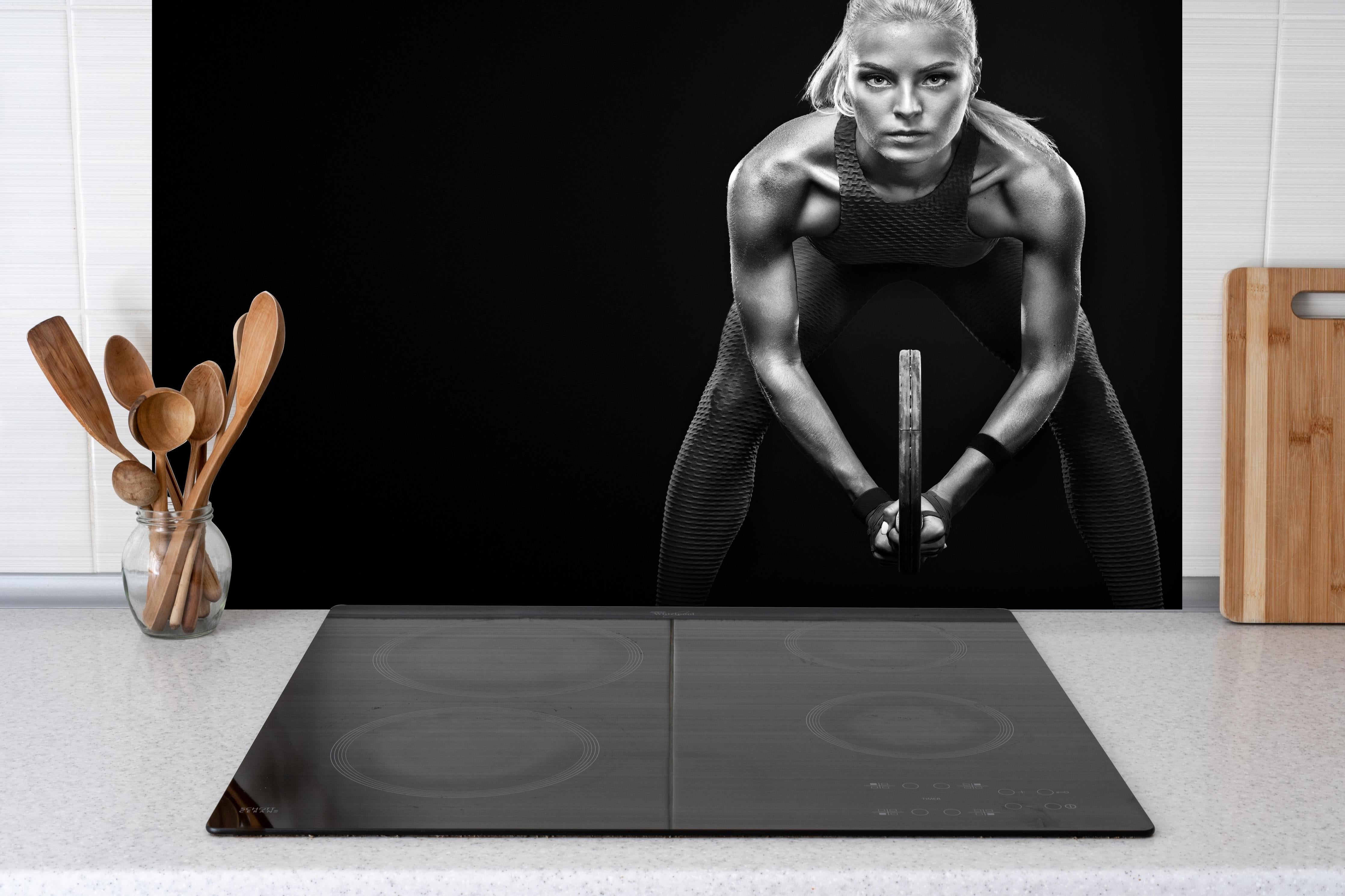 Spritzschutz - Schwarz-weiß Ansicht - Tennisspielerin hinter einem Cerankochfeld zwischen Holz-Kochutensilien