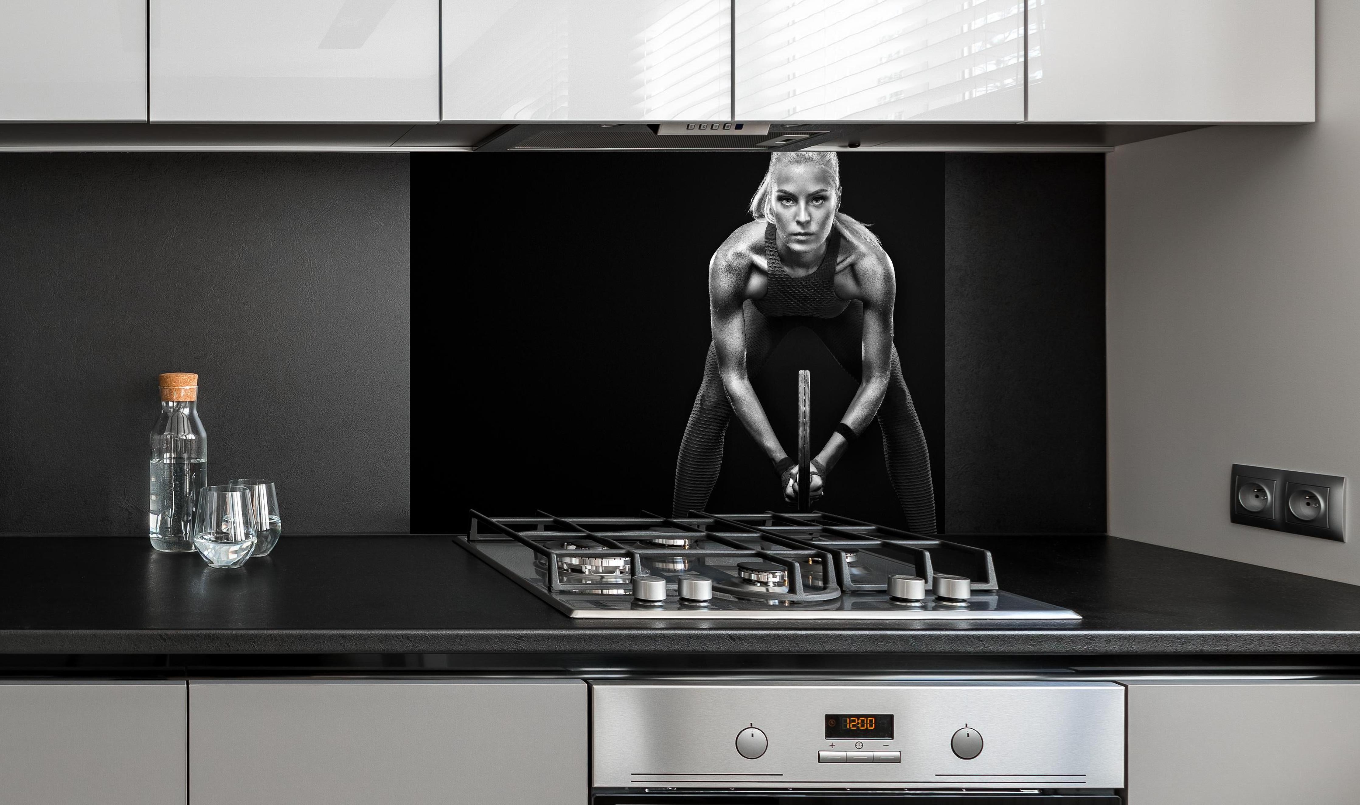 Spritzschutz - Schwarz-weiß Ansicht - Tennisspielerin hinter einem Cerankochfeld zwischen Holz-Kochutensilien