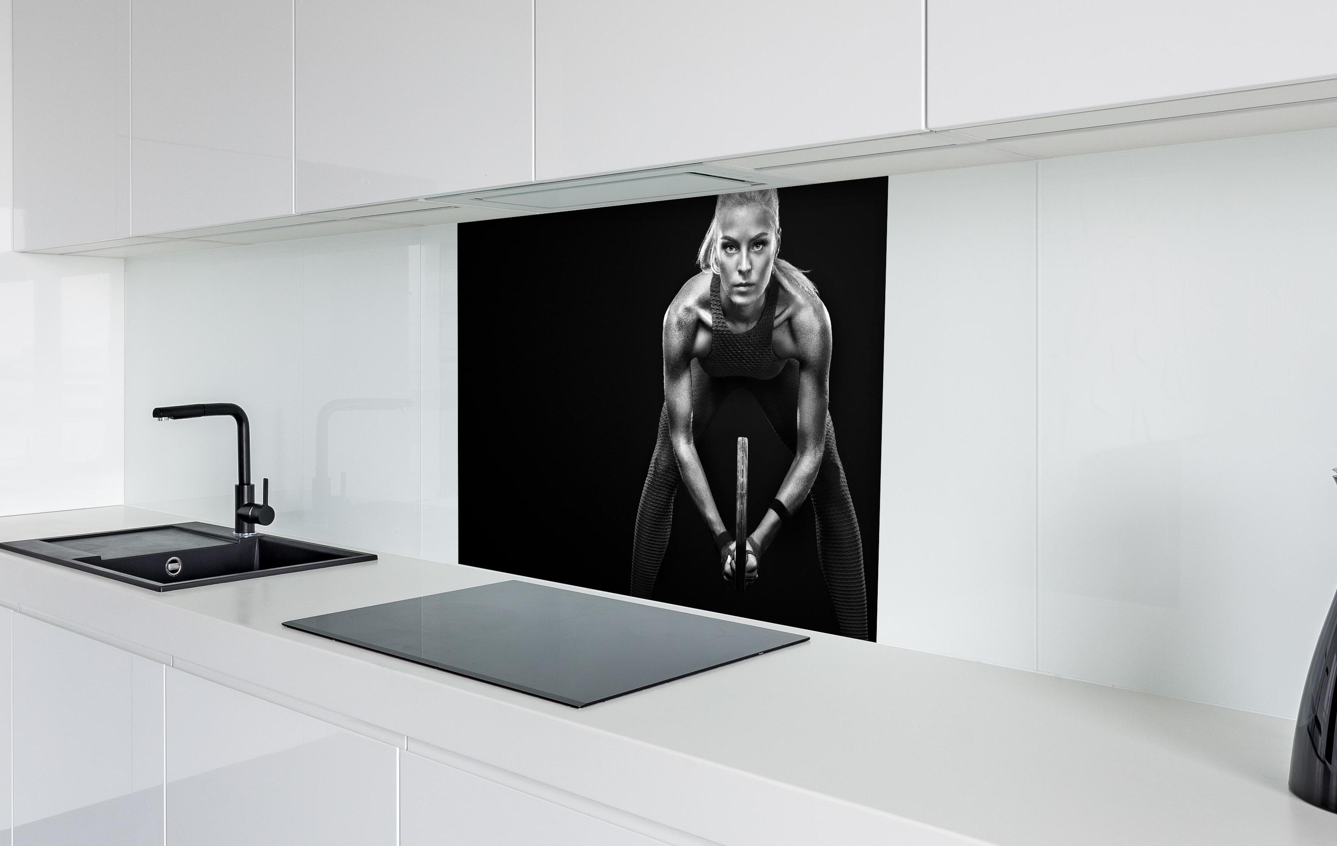 Spritzschutz - Schwarz-weiß Ansicht - Tennisspielerin hinter einem Cerankochfeld zwischen Holz-Kochutensilien