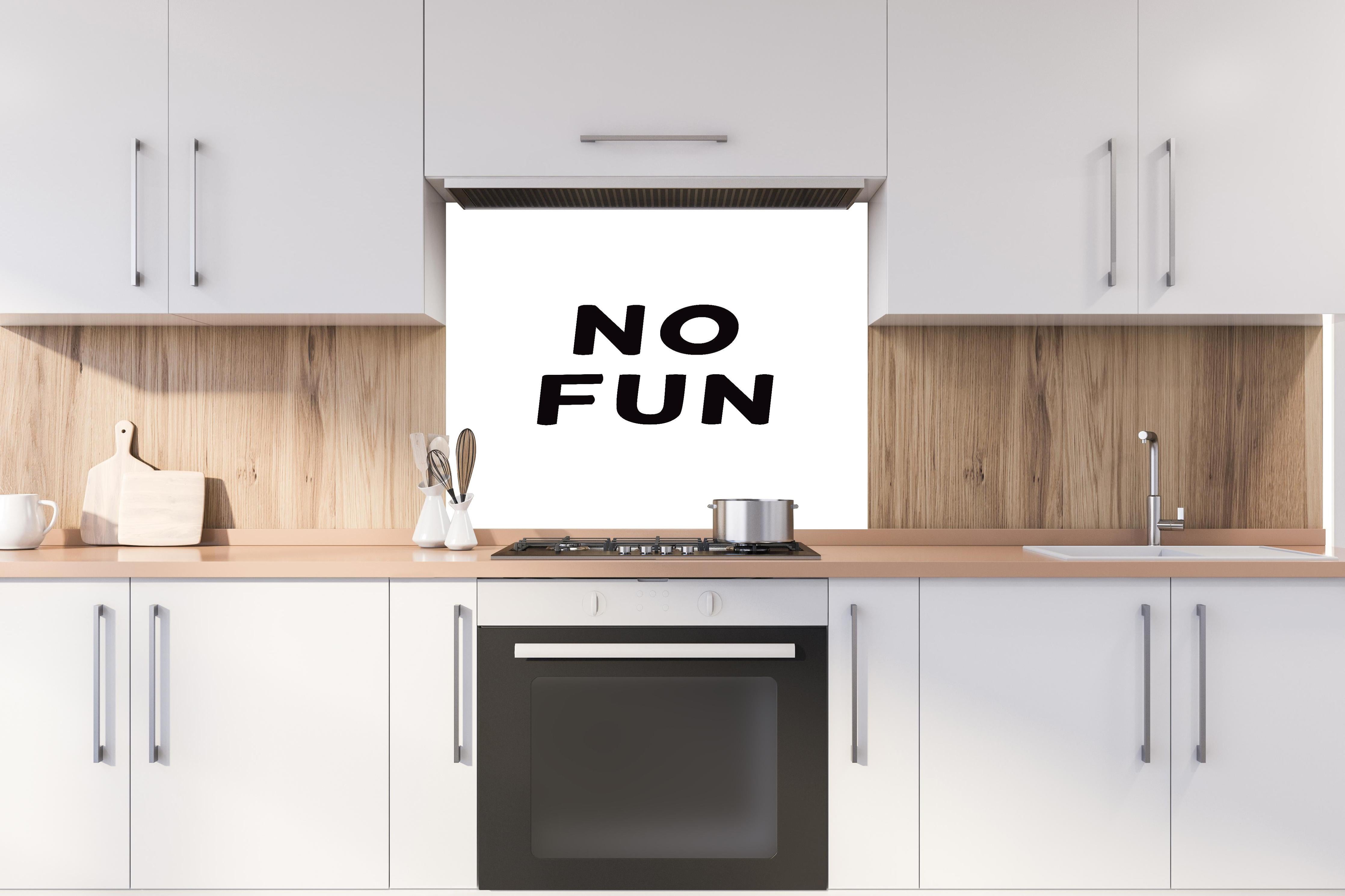 Spritzschutz - Schwarze Typografie 'No Fun' auf Weiß hinter einem Cerankochfeld zwischen Holz-Kochutensilien
