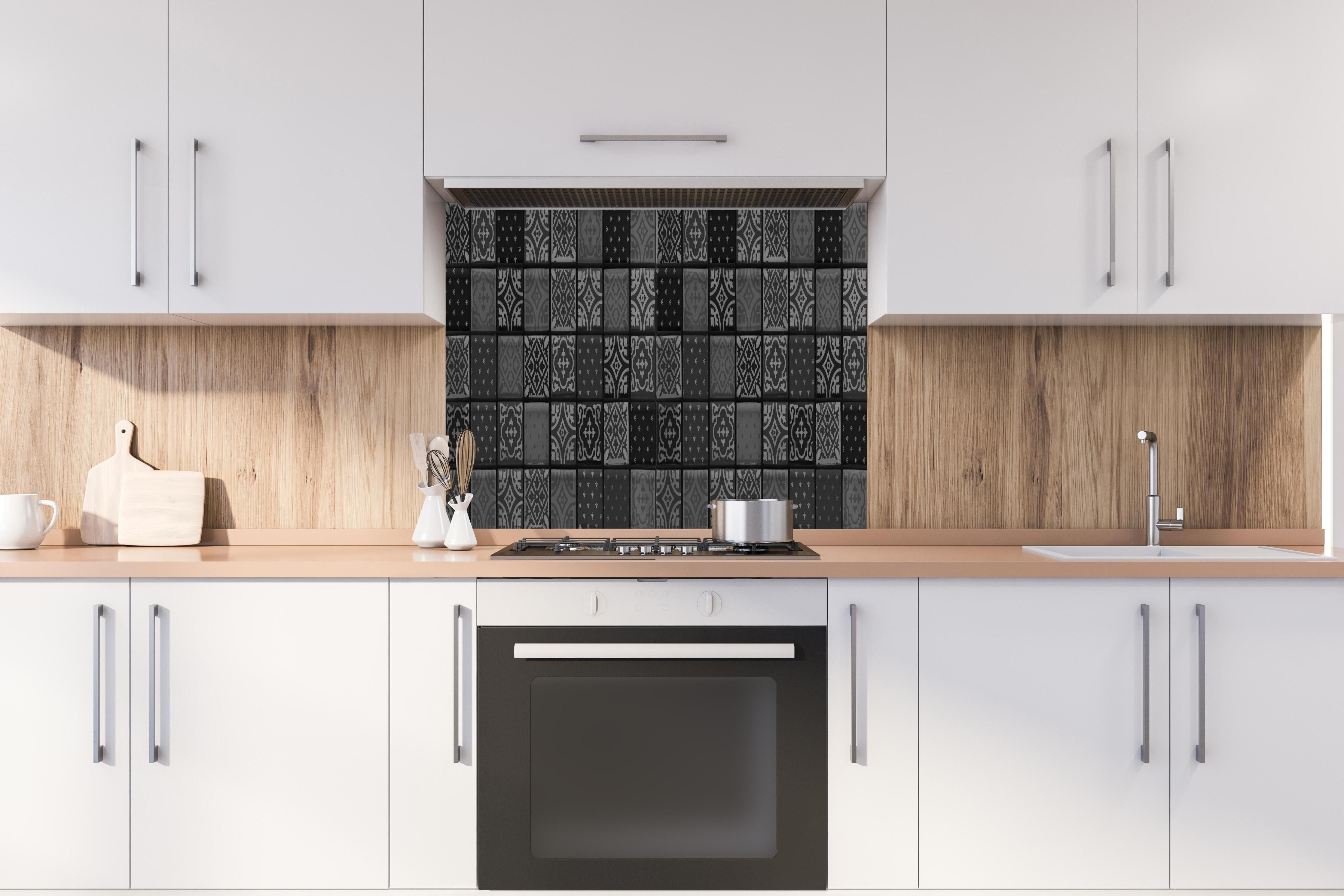 Spritzschutz - Schwarze anthrazit Fliesen hinter einem Cerankochfeld zwischen Holz-Kochutensilien