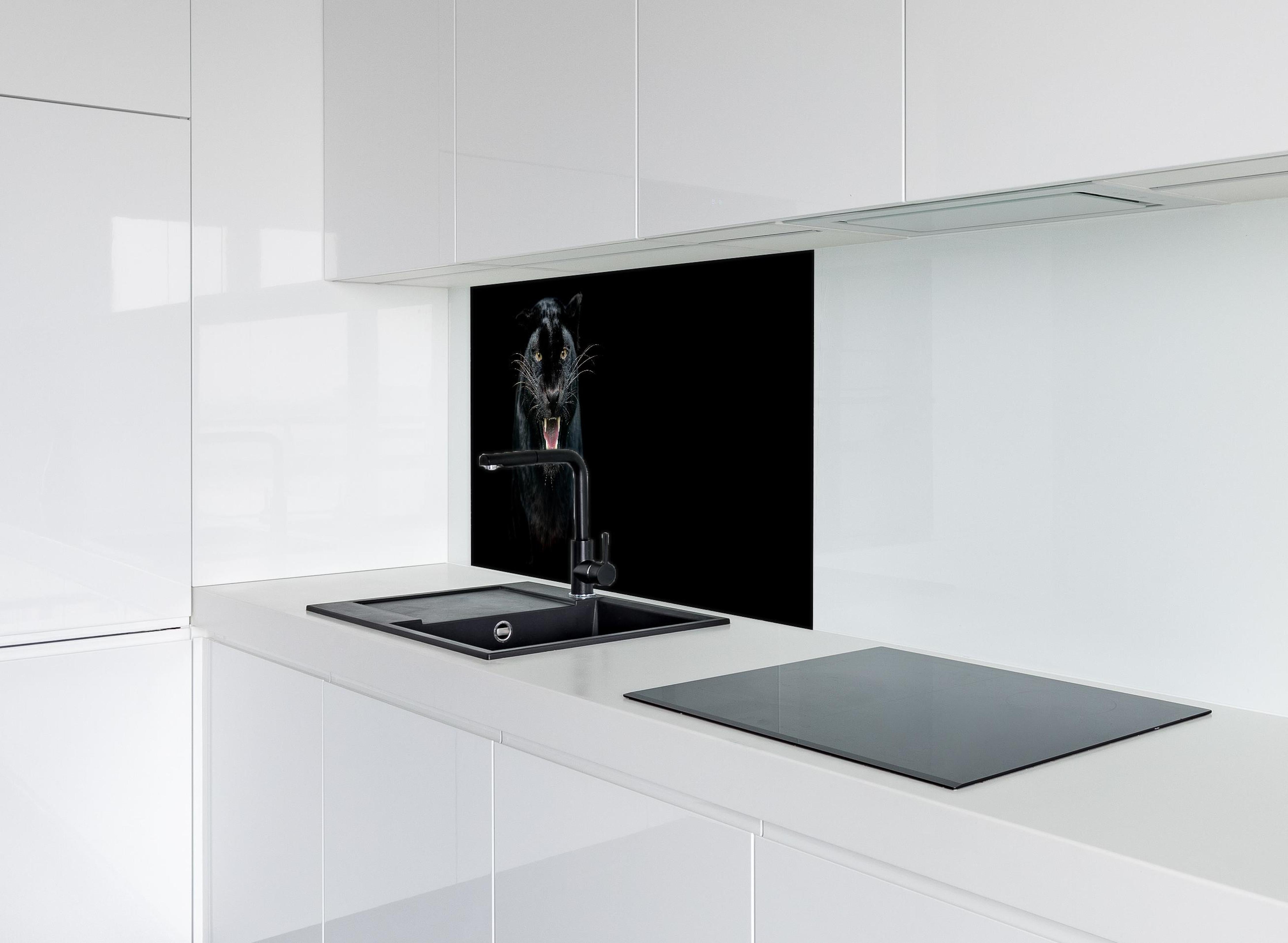 Spritzschutz - Schwarzer Panther auf schwarzem Hintergrund hinter einem Cerankochfeld zwischen Holz-Kochutensilien