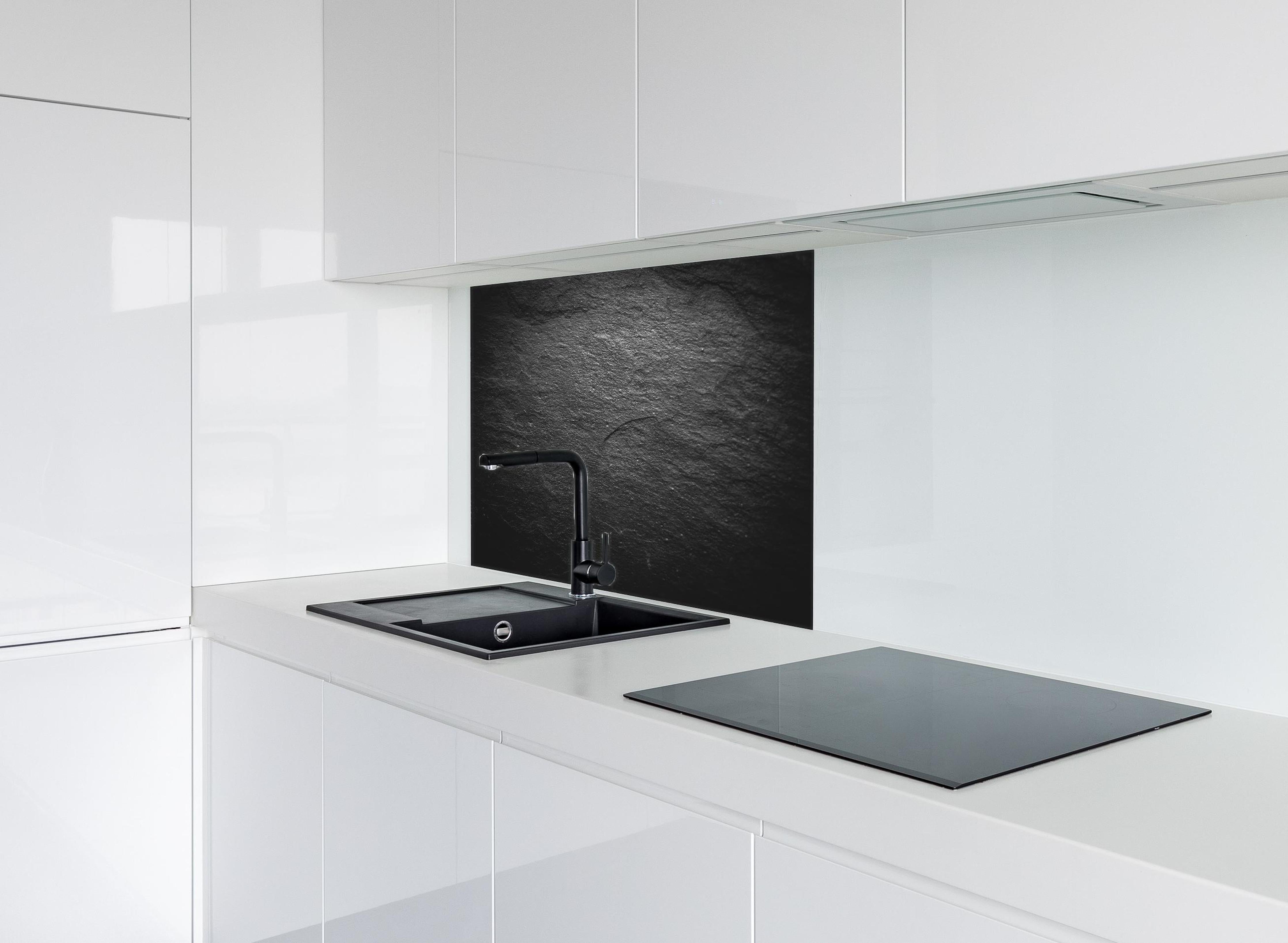 Spritzschutz - Schwarzer Schieferstein hinter einem Cerankochfeld zwischen Holz-Kochutensilien