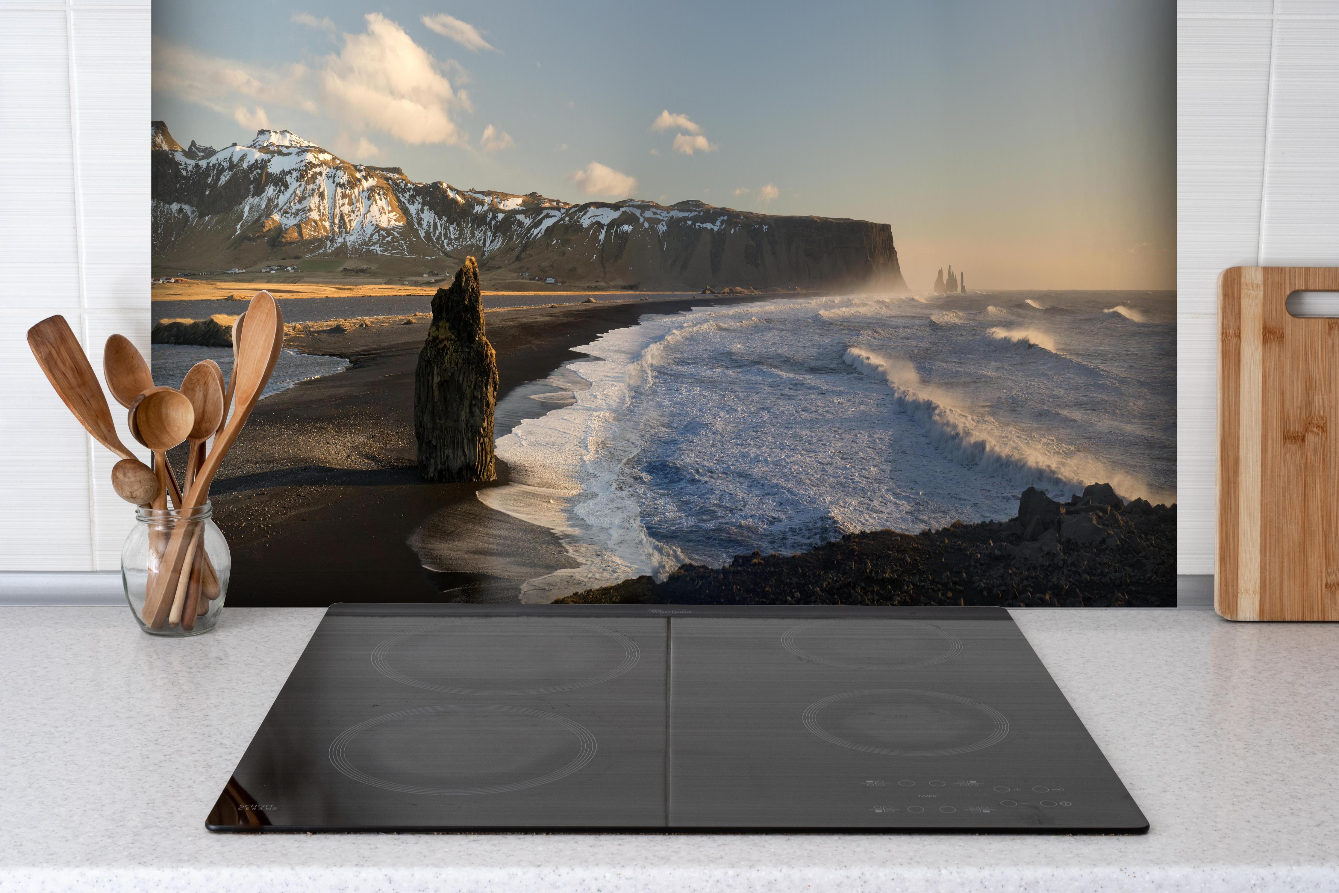 Spritzschutz - Schwarzer Strand von Dyrholaey hinter einem Cerankochfeld zwischen Holz-Kochutensilien