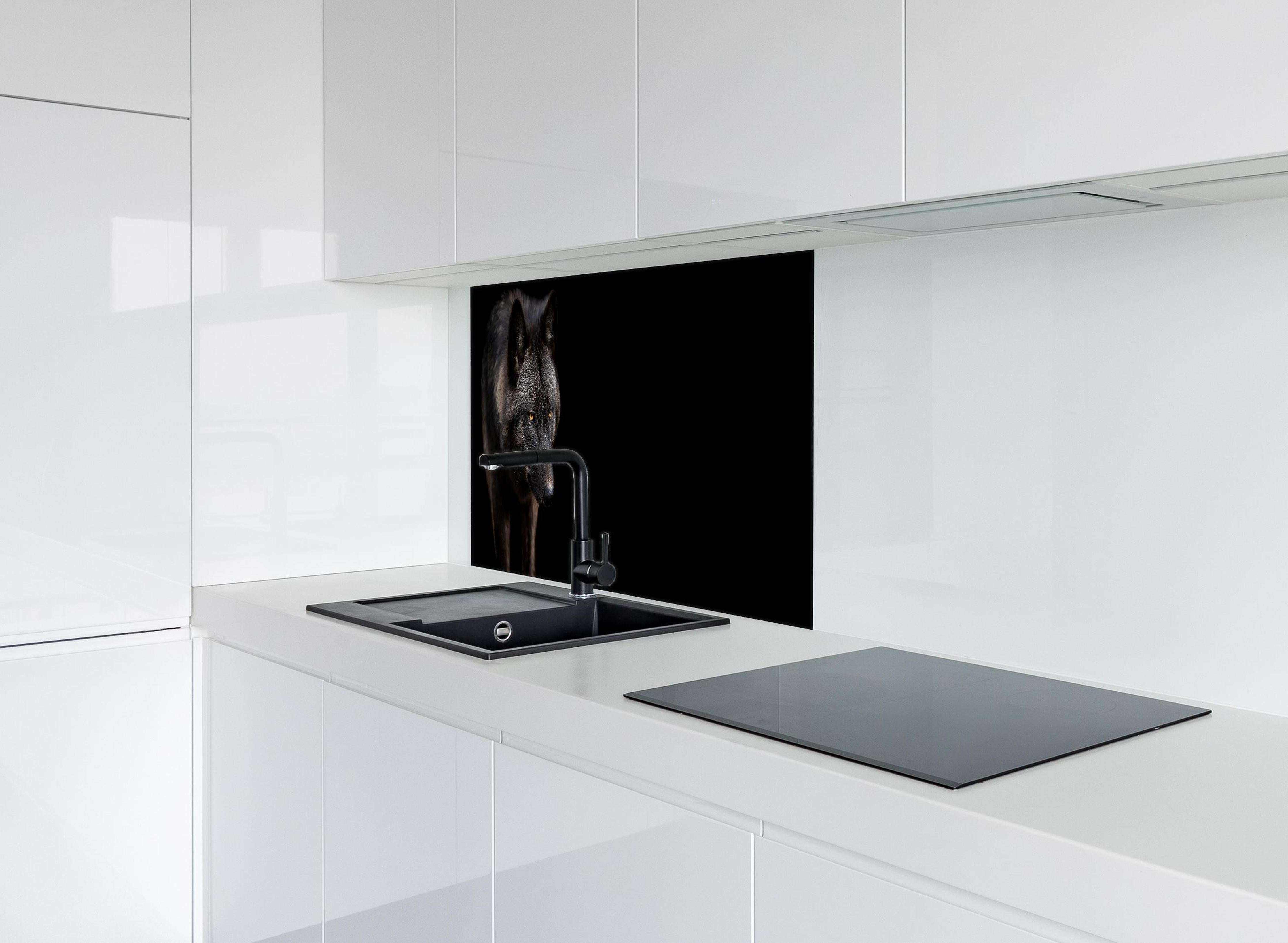 Spritzschutz - Schwarzer Wolf auf schwarzem Hintergrund hinter einem Cerankochfeld zwischen Holz-Kochutensilien