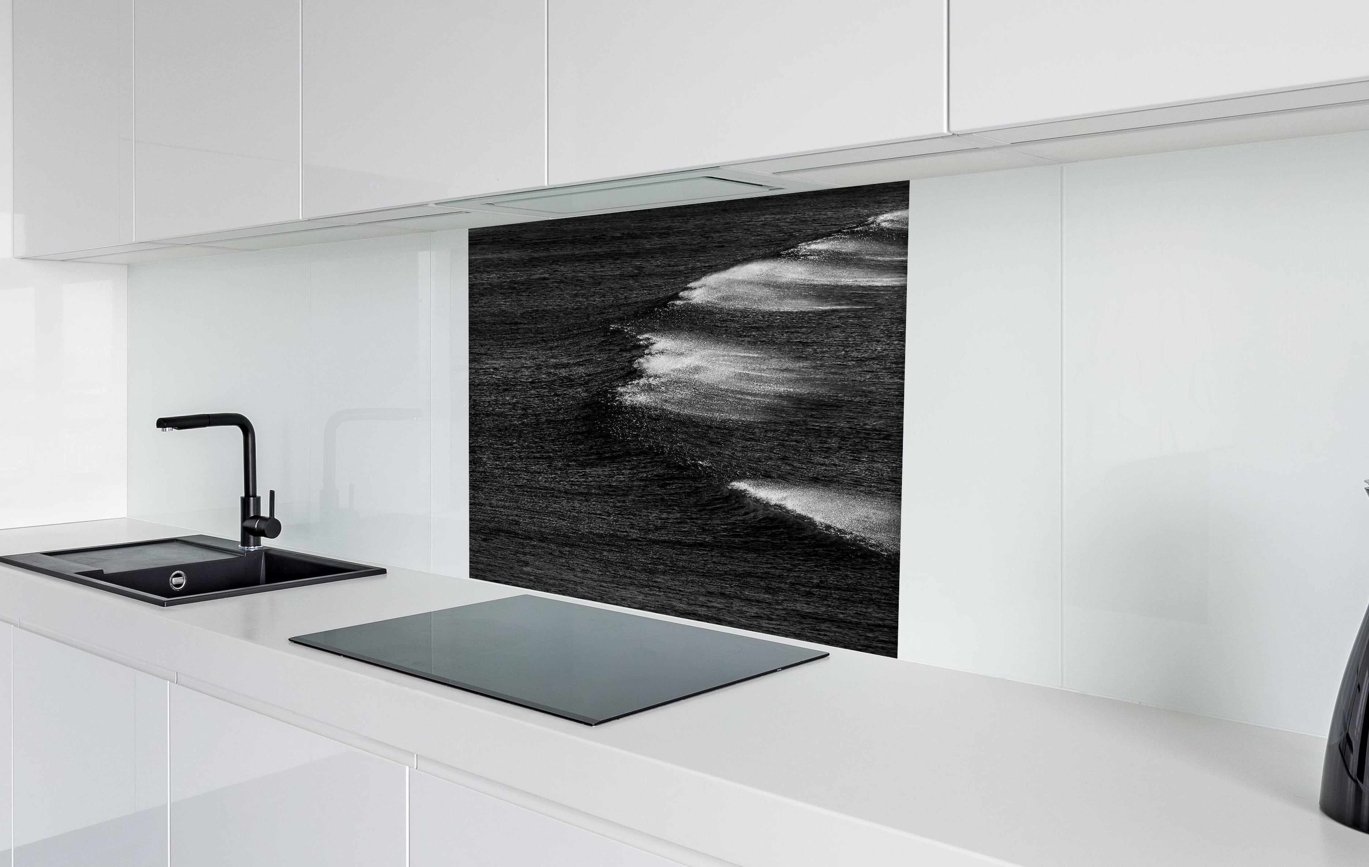 Spritzschutz - Schwarzweiße Ozeanwellen aus der Vogelperspektive hinter einem Cerankochfeld zwischen Holz-Kochutensilien