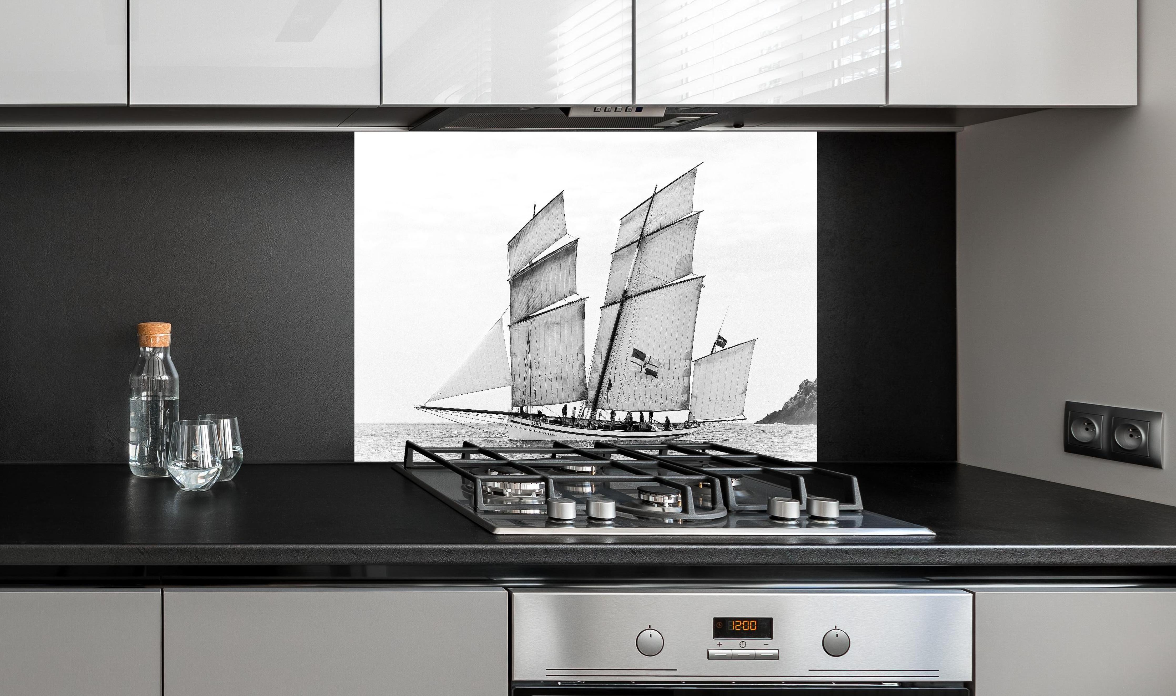 Spritzschutz - Segelboot auf dem Meer hinter einem Cerankochfeld zwischen Holz-Kochutensilien