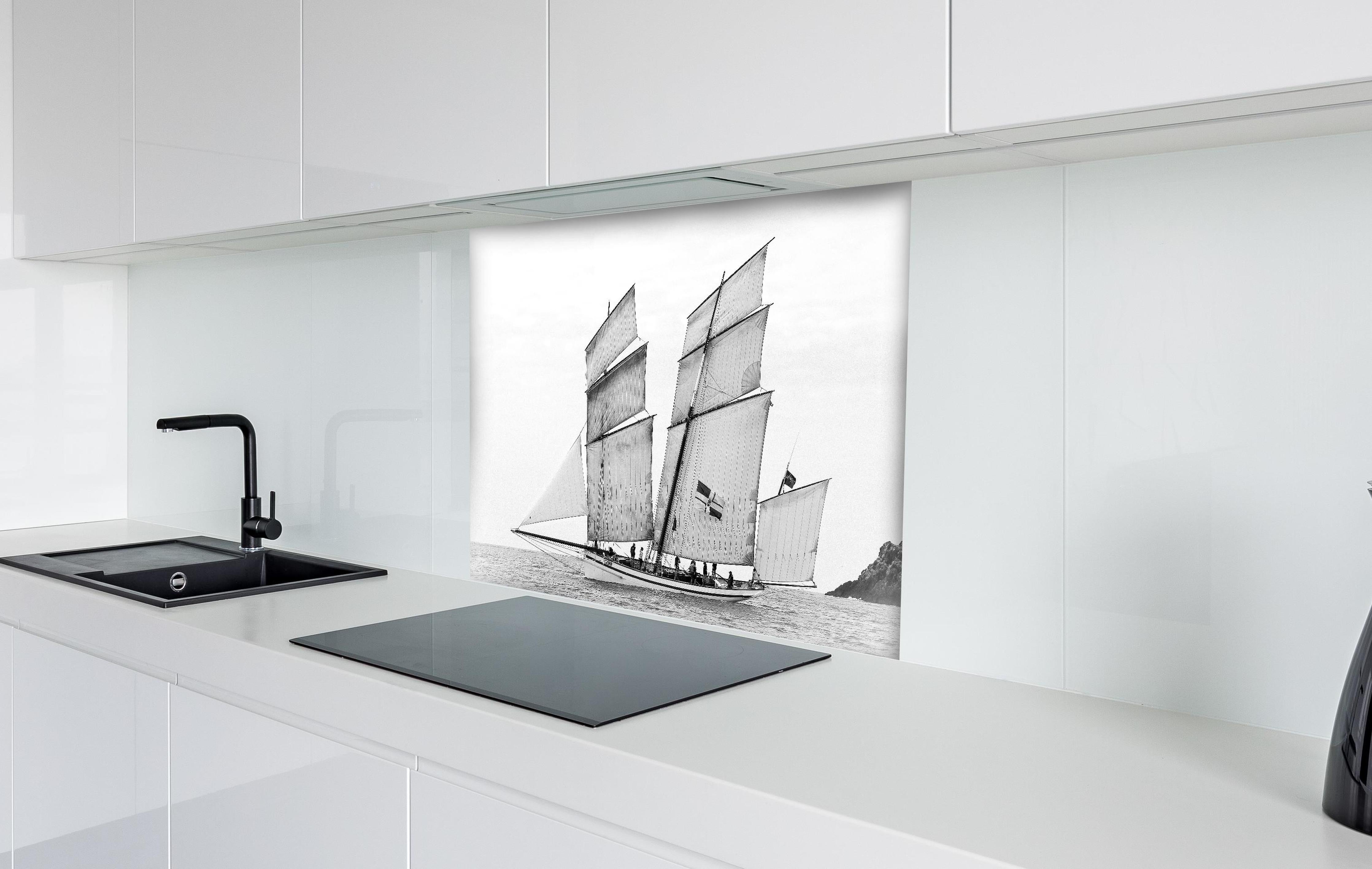 Spritzschutz - Segelboot auf dem Meer hinter einem Cerankochfeld zwischen Holz-Kochutensilien