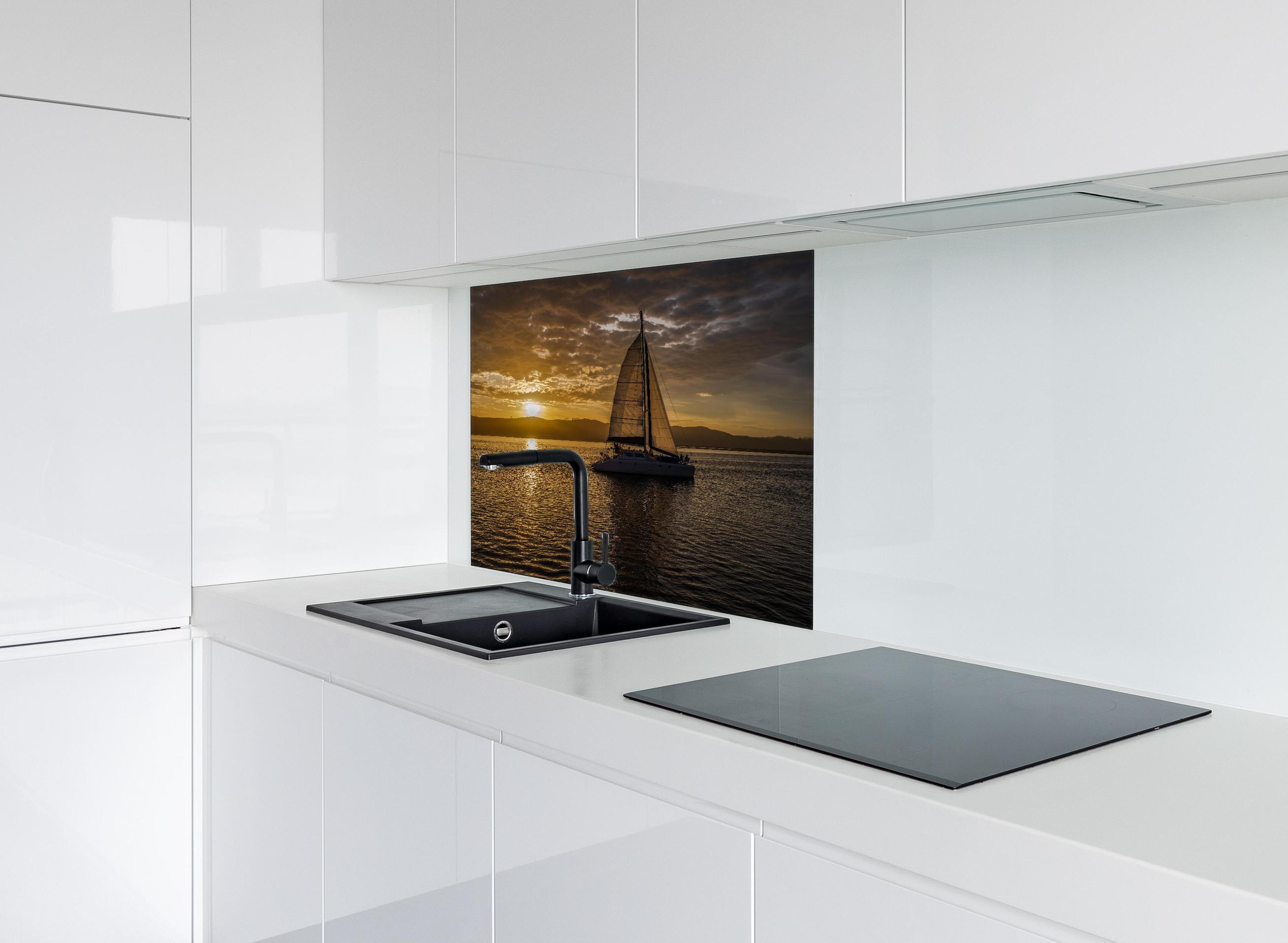 Spritzschutz - Segelboot bei Sonnenuntergang in der Lagune von Knysna hinter einem Cerankochfeld zwischen Holz-Kochutensilien