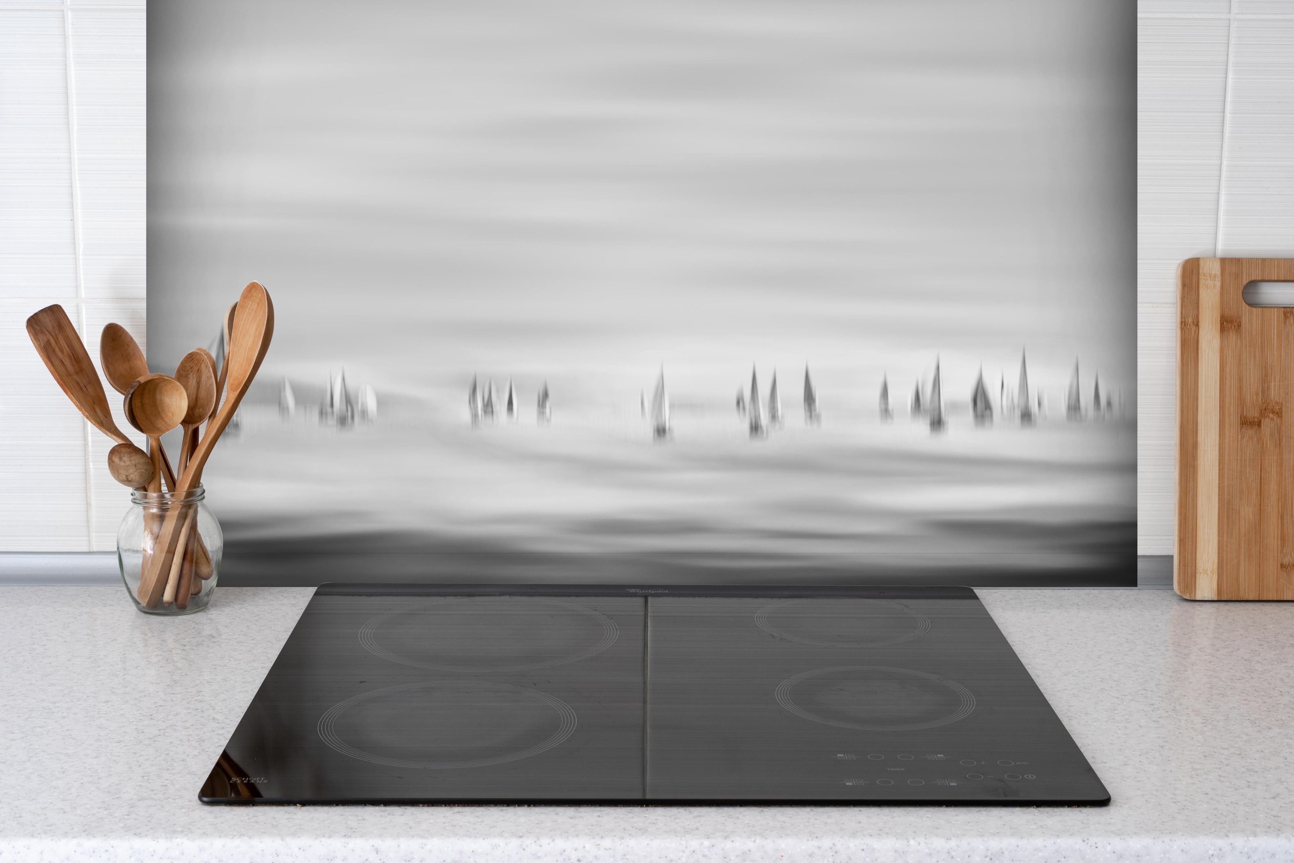 Spritzschutz - Segelboote am Meer - Unscharf hinter einem Cerankochfeld zwischen Holz-Kochutensilien