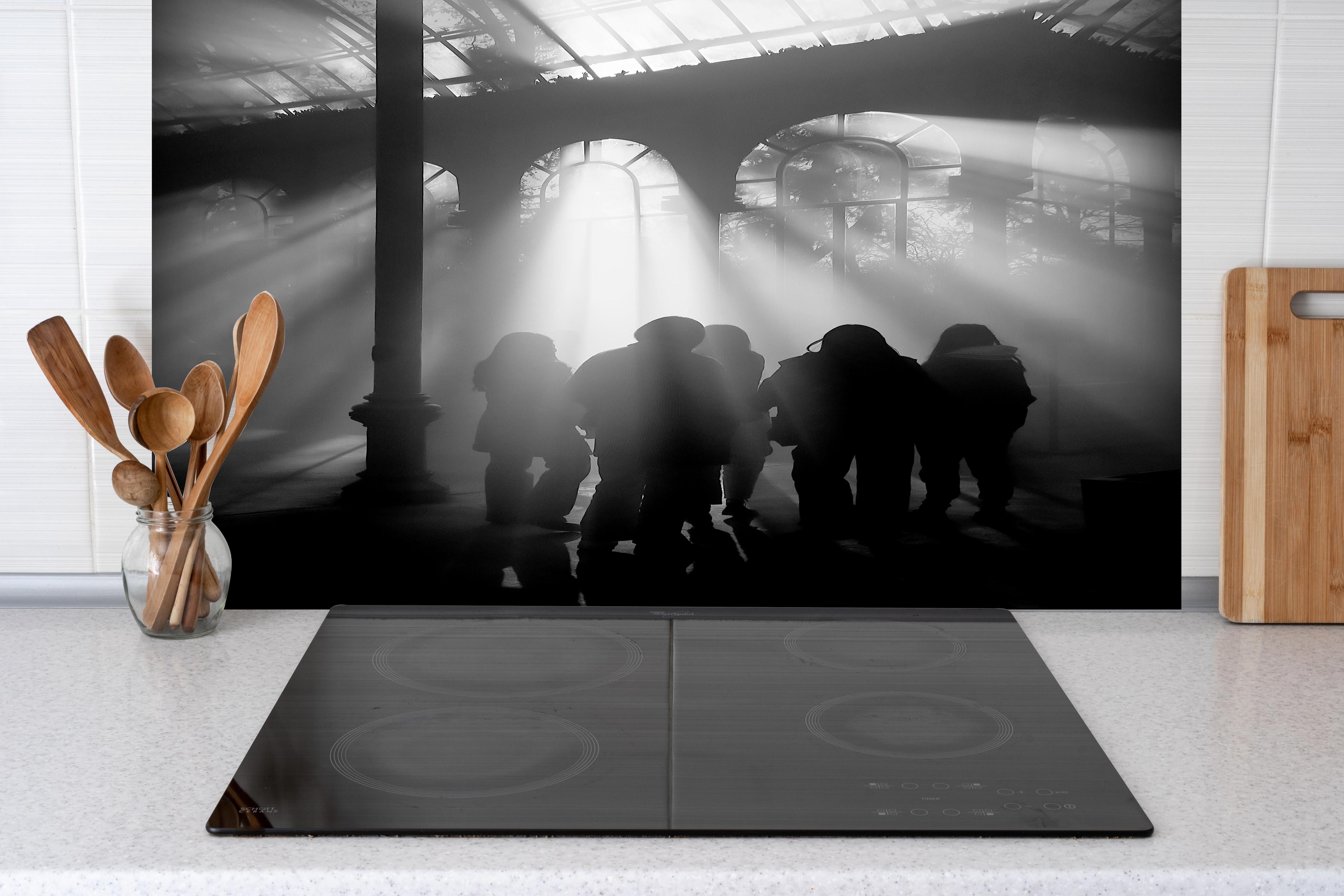 Spritzschutz - Silhouetten von Menschen hinter einem Cerankochfeld zwischen Holz-Kochutensilien
