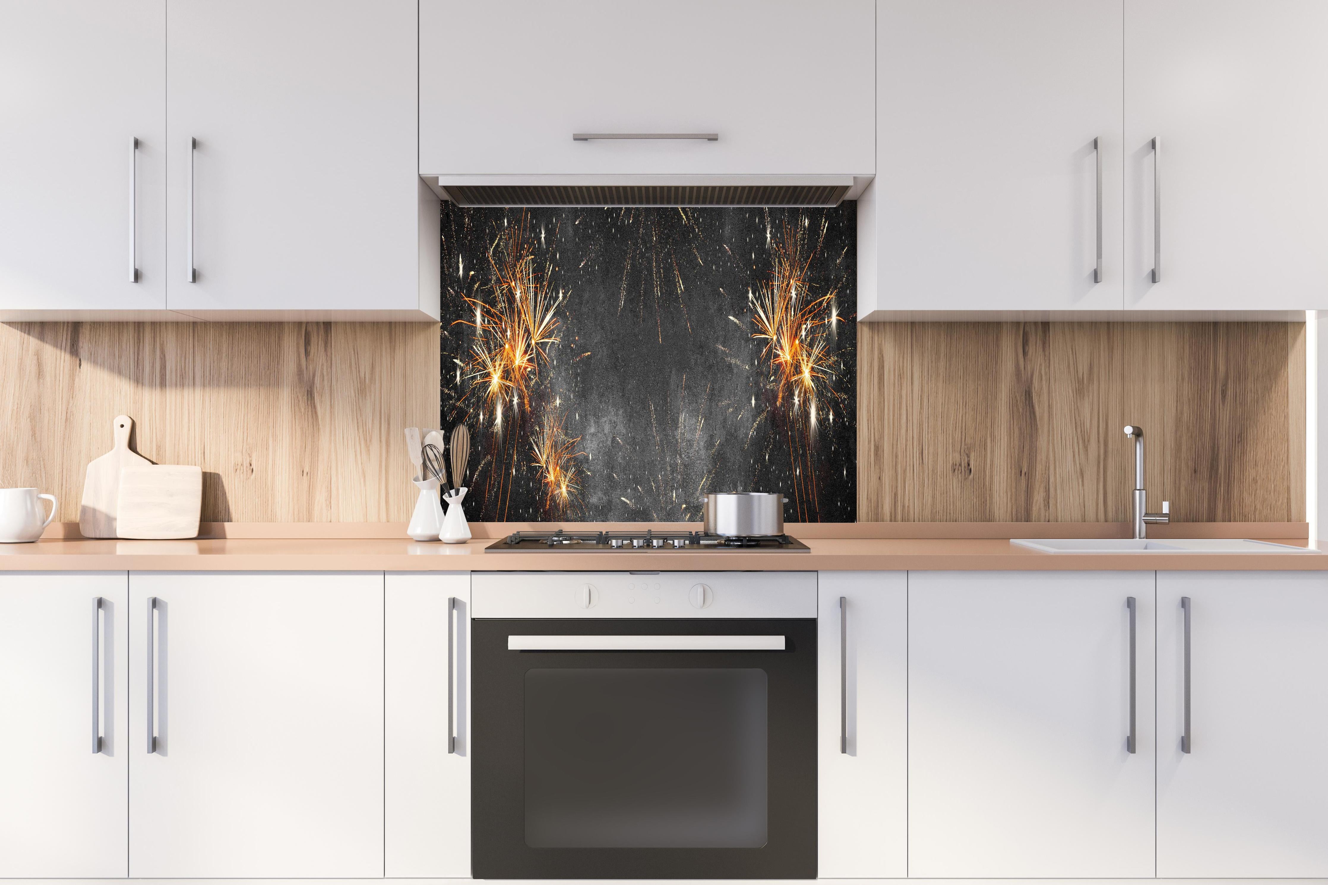 Spritzschutz - Silvesterparty Feuerwerk auf Grauschwarz hinter einem Cerankochfeld zwischen Holz-Kochutensilien
