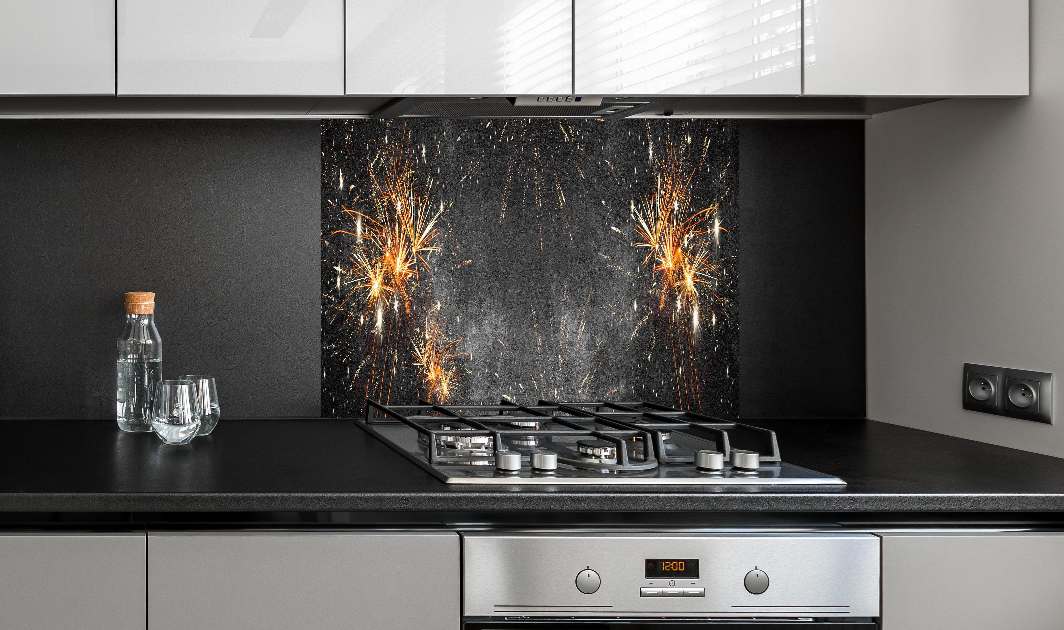 Spritzschutz - Silvesterparty Feuerwerk auf Grauschwarz hinter einem Cerankochfeld zwischen Holz-Kochutensilien