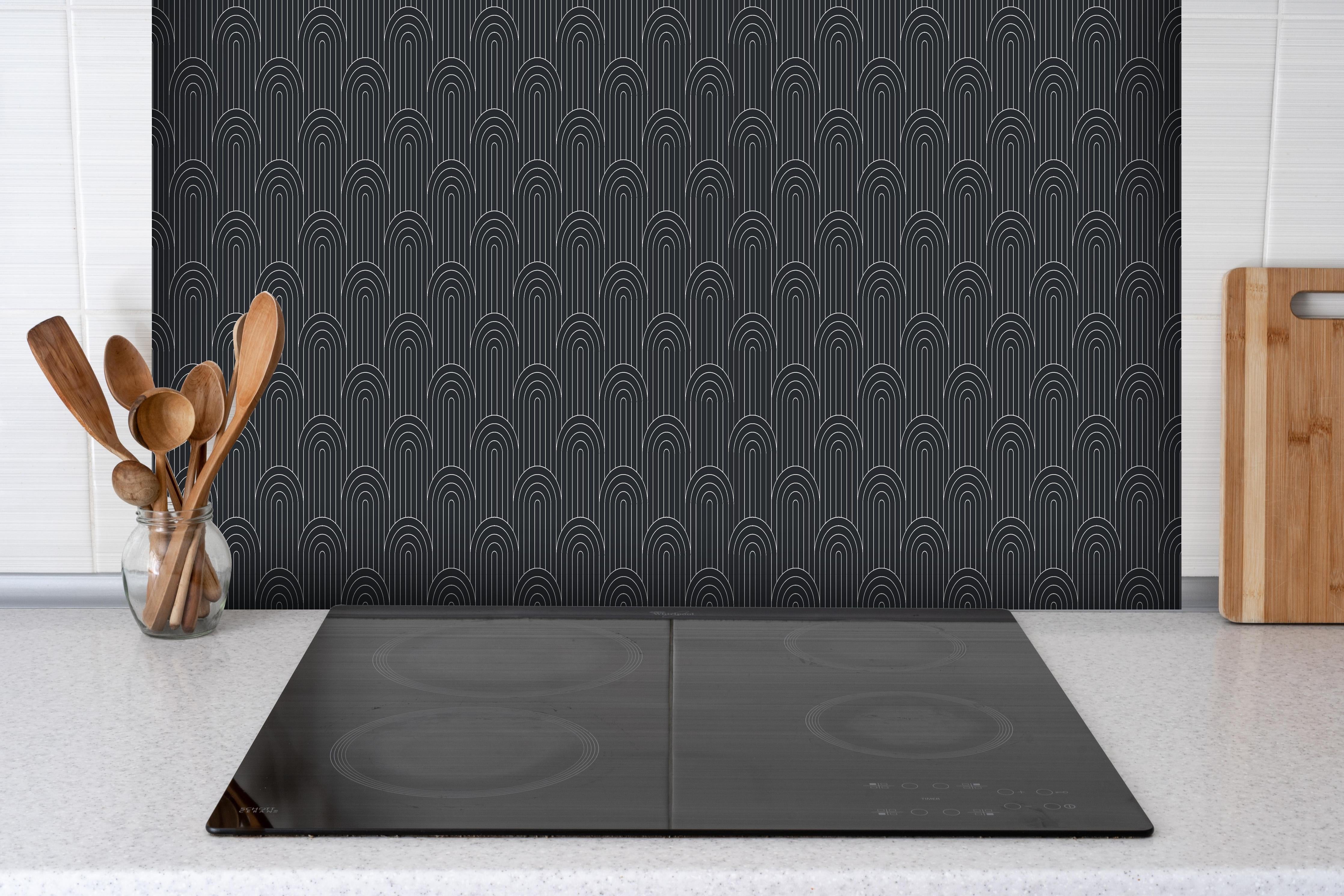 Spritzschutz - Simmetria Arcate Carbone hinter einem Cerankochfeld zwischen Holz-Kochutensilien