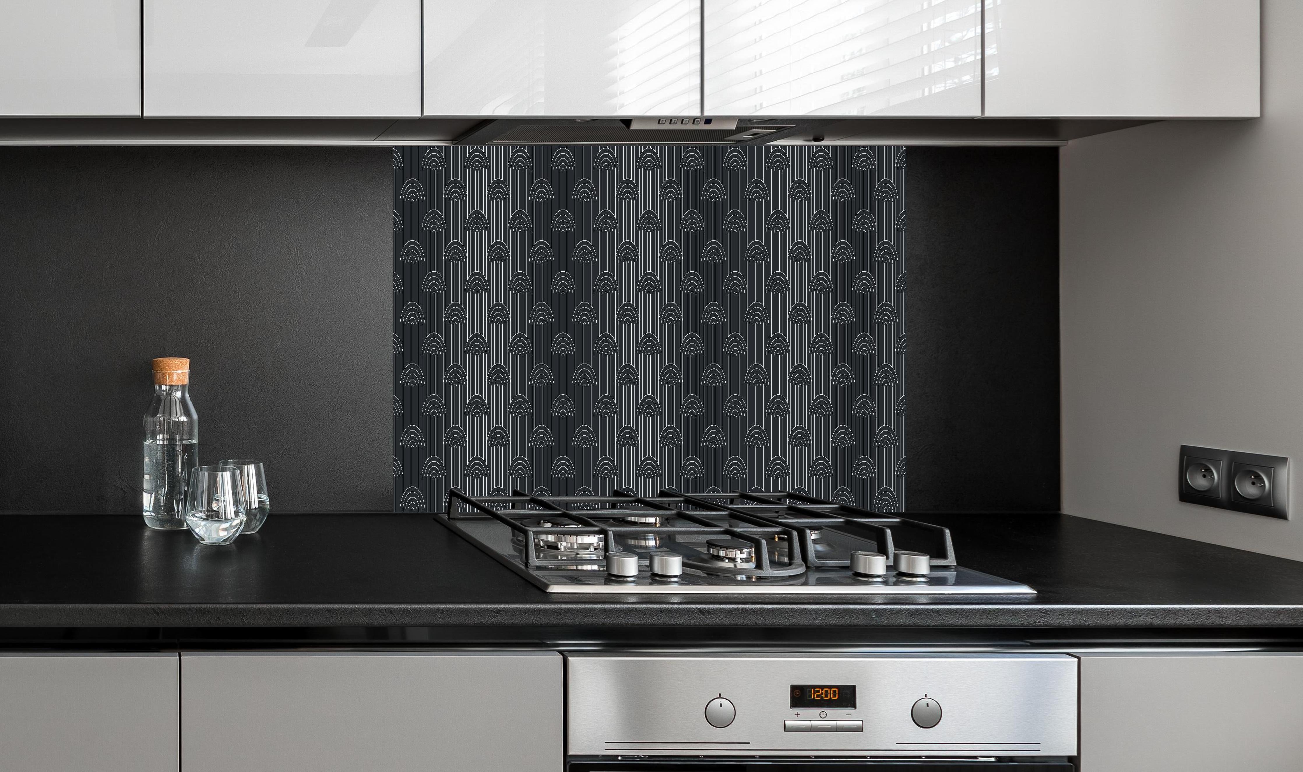 Spritzschutz - Simmetria Arcate Carbone hinter einem Cerankochfeld zwischen Holz-Kochutensilien