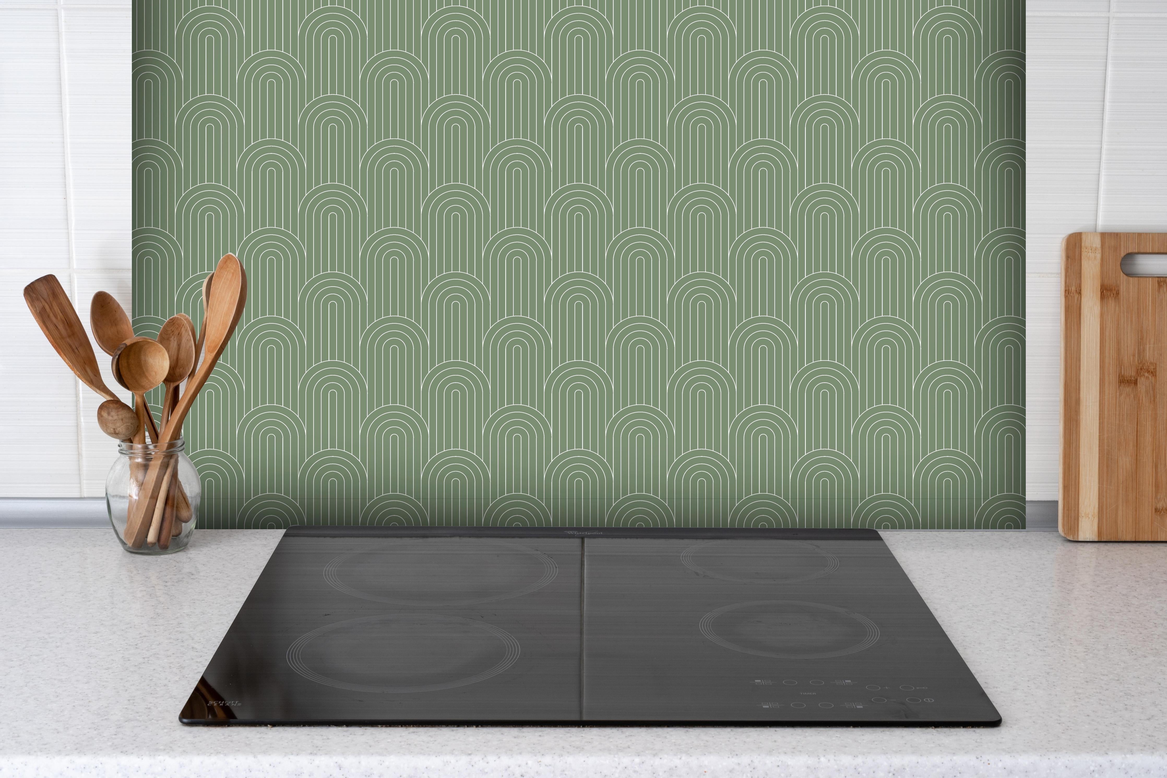 Spritzschutz - Simmetria Arcate Oliva hinter einem Cerankochfeld zwischen Holz-Kochutensilien