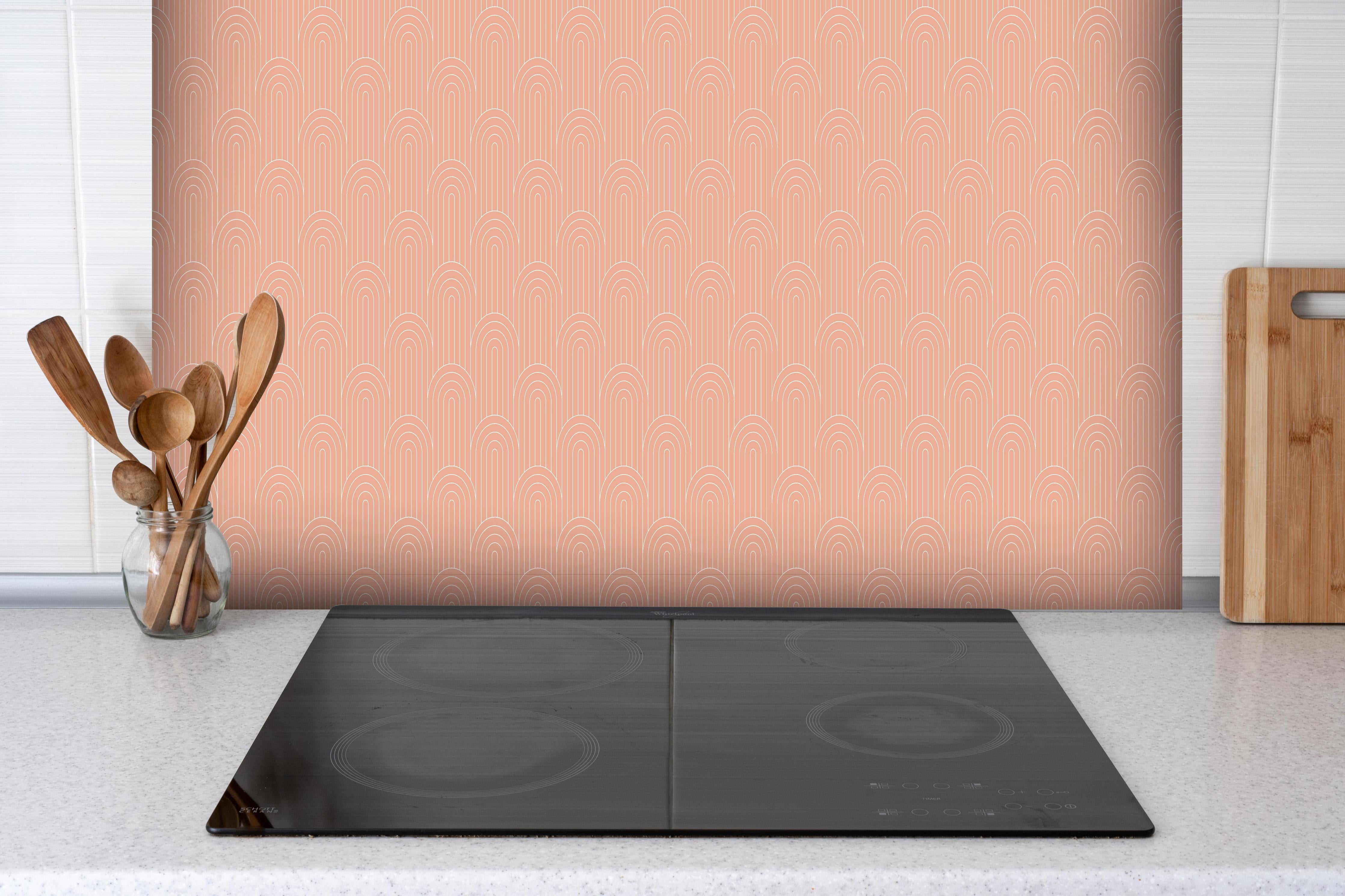 Spritzschutz - Simmetria Arcate Salmone hinter einem Cerankochfeld zwischen Holz-Kochutensilien
