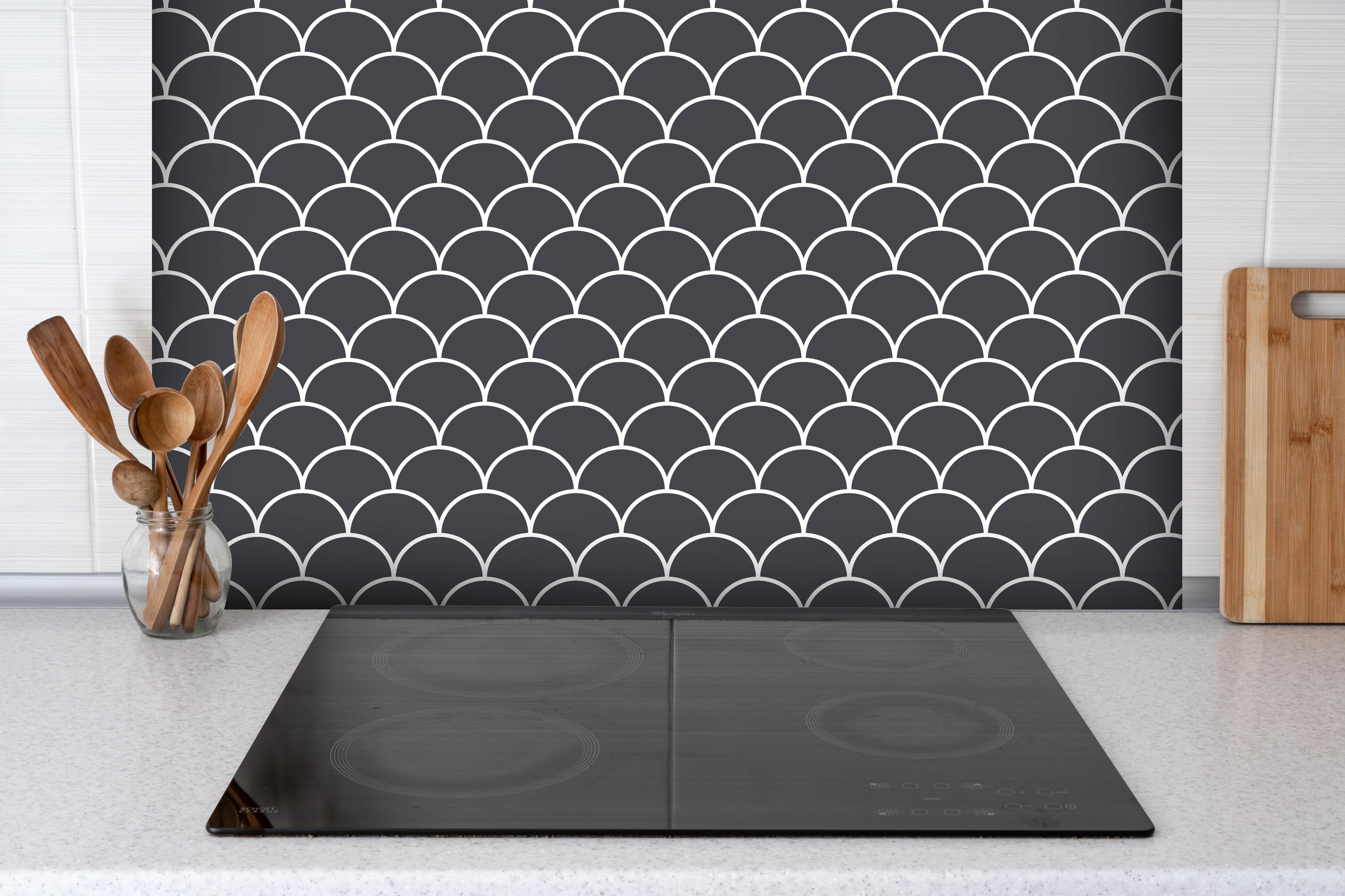 Spritzschutz - Simmetria Imperiale Antracite hinter einem Cerankochfeld zwischen Holz-Kochutensilien